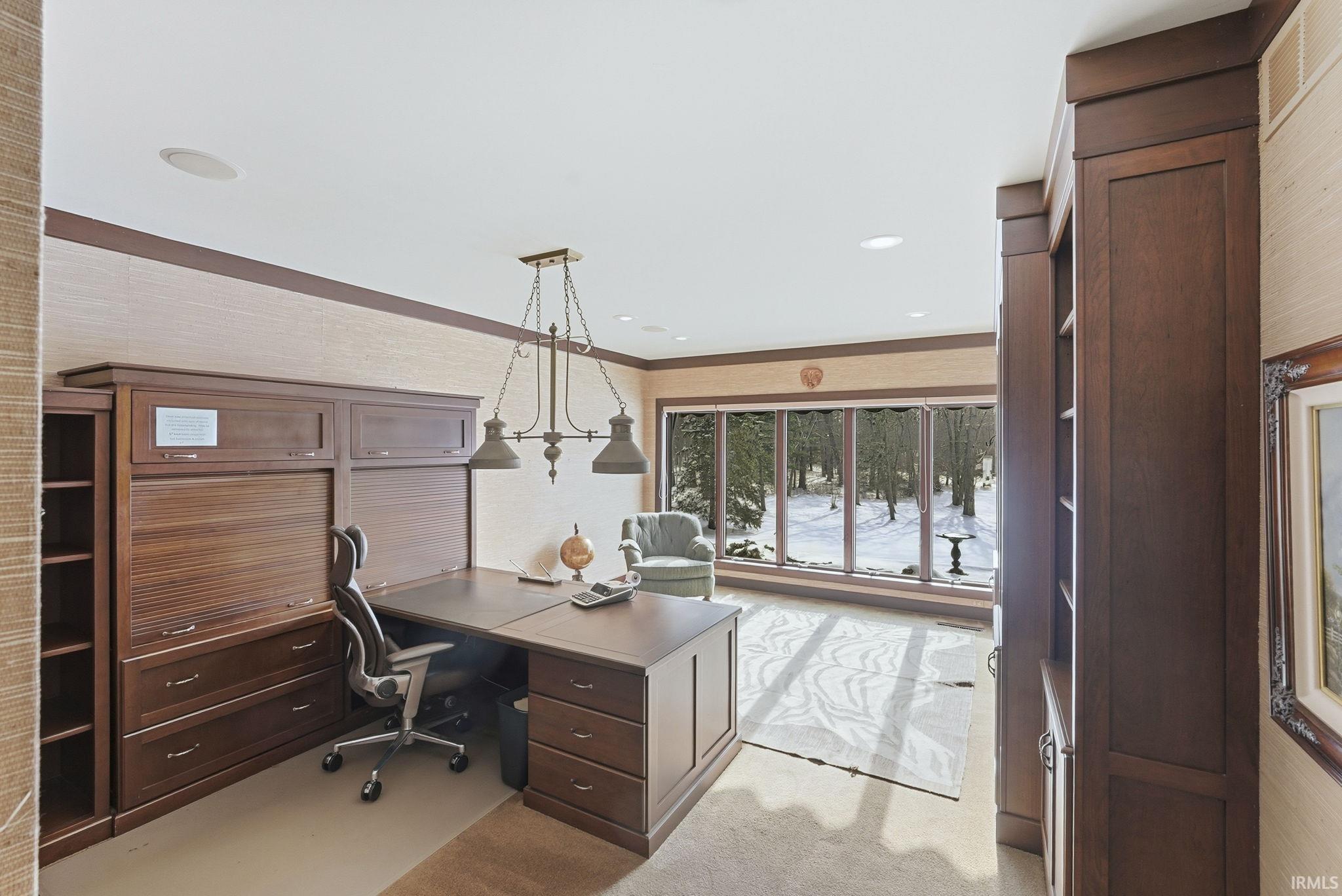 Office space with crown molding and light carpet