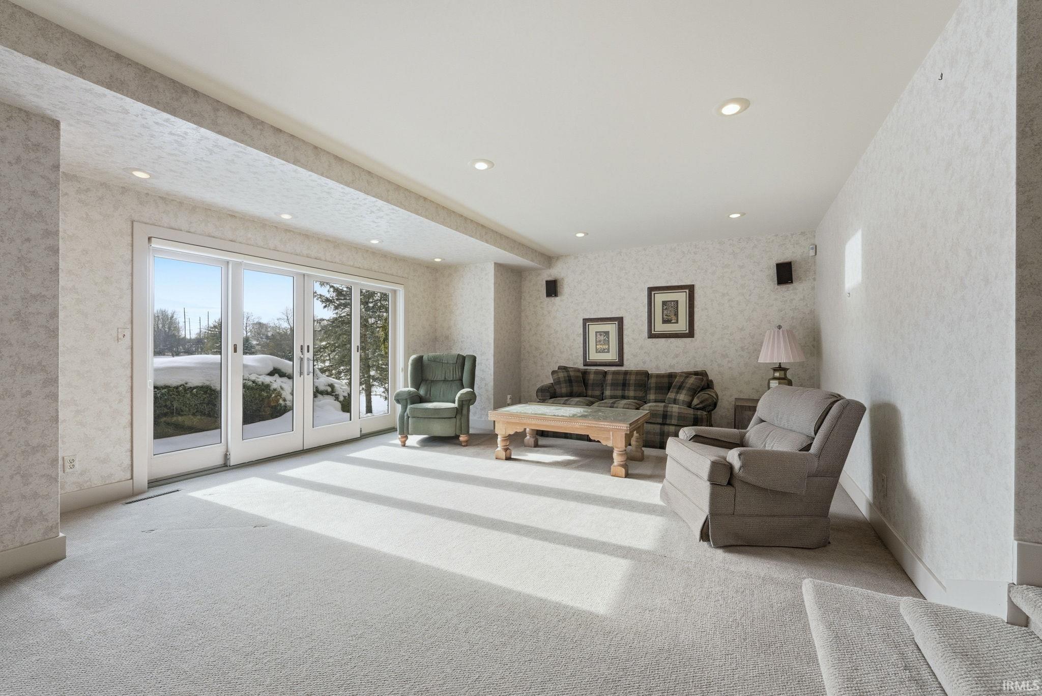 Living area featuring wallpapered walls, healthy amount of natural light, carpet, and recessed lighting