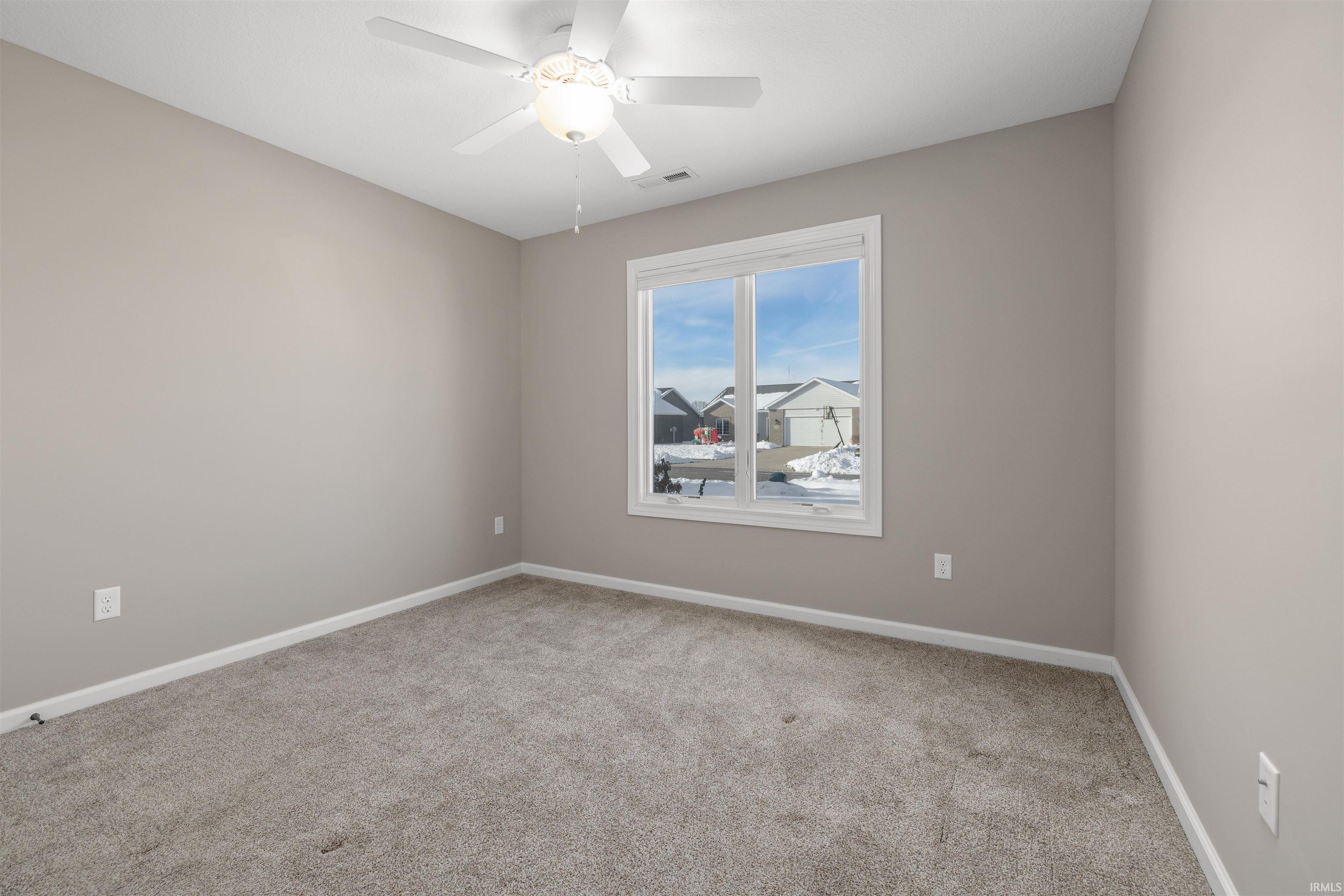 Spare room with light colored carpet and a ceiling fan