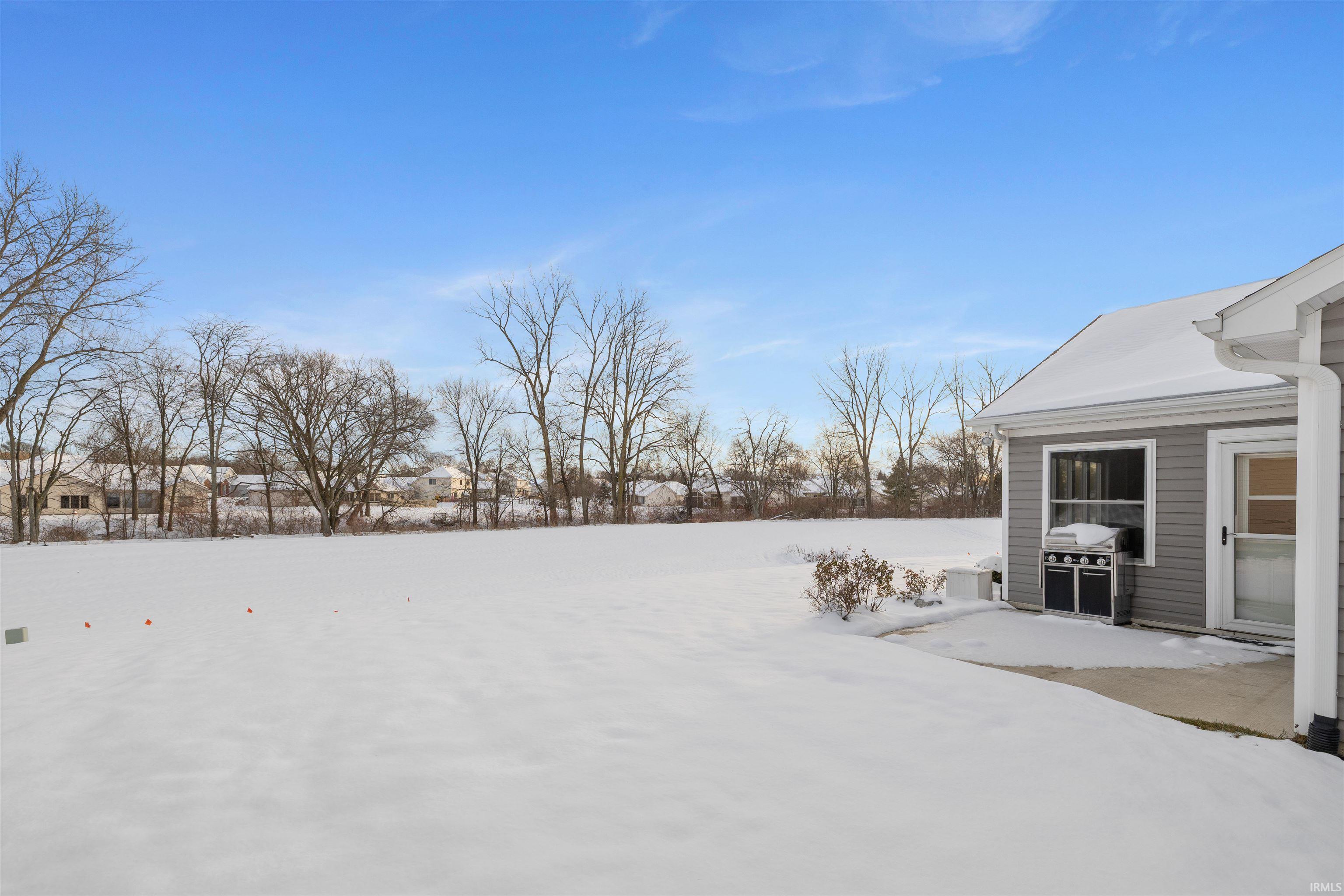 Snowy yard featuring a patio area