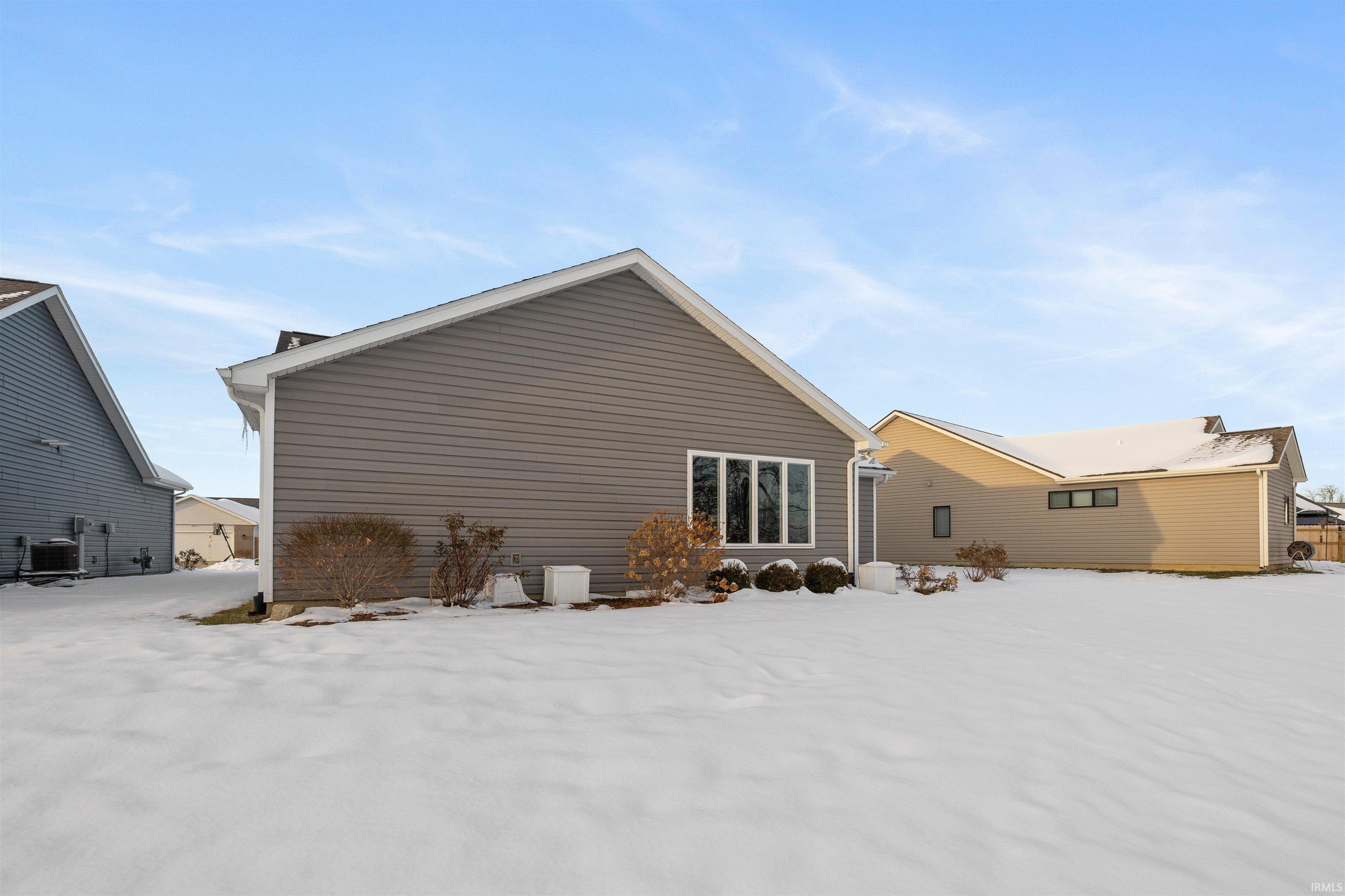 View of snow covered back of property
