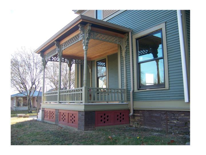 View of side of property with a porch and a yard