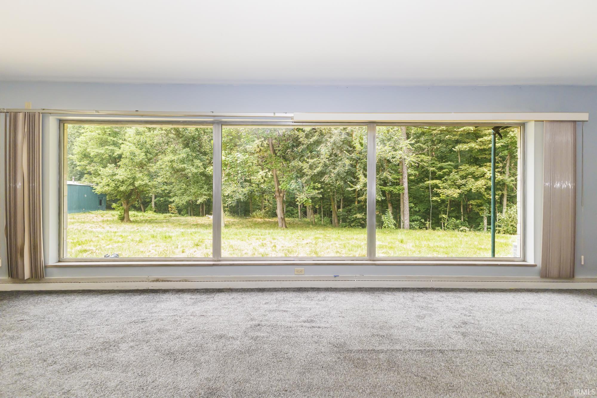 Expansive picture windows framing a verdant outdoor landscape