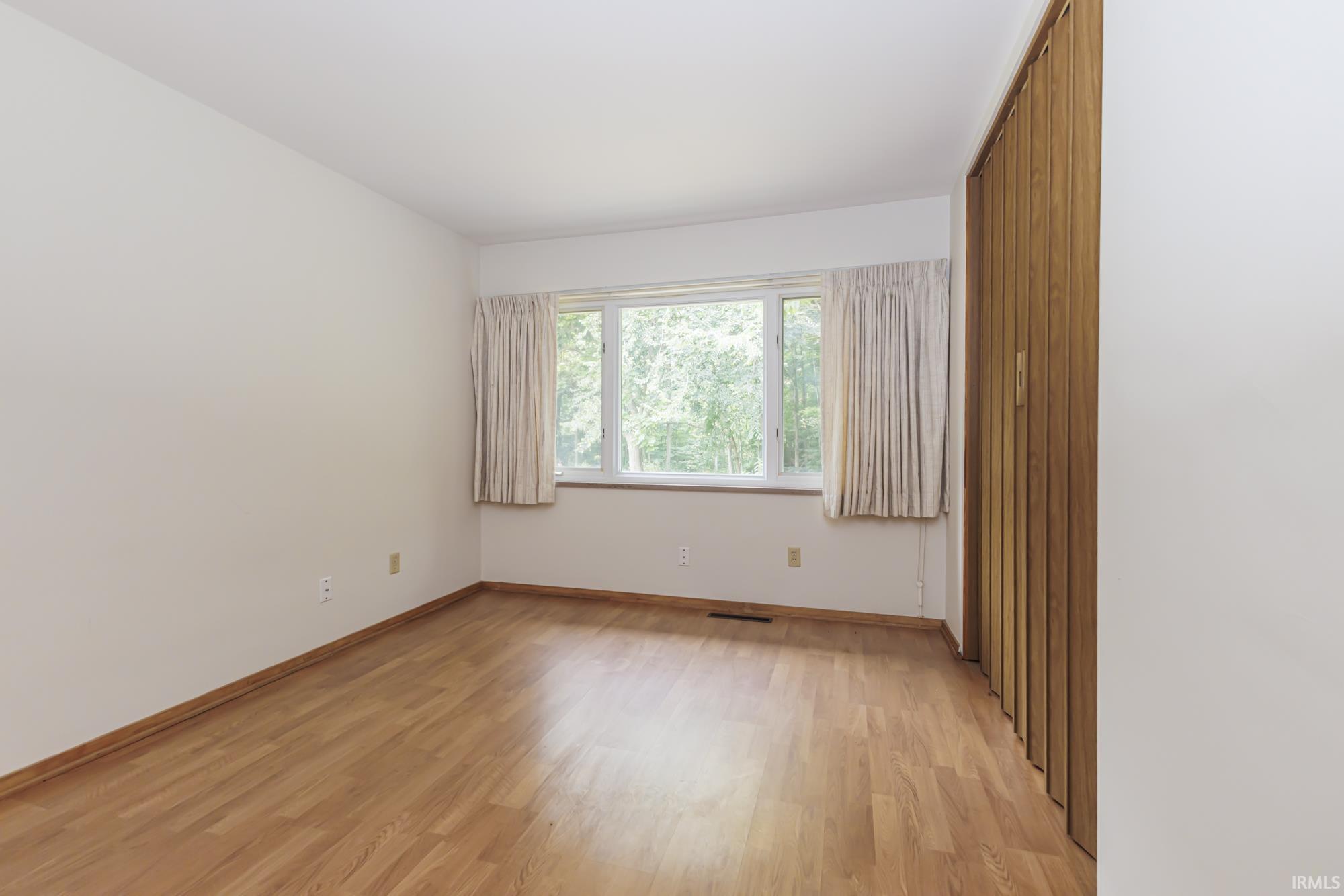 Light wood-finish flooring with white baseboards throughout