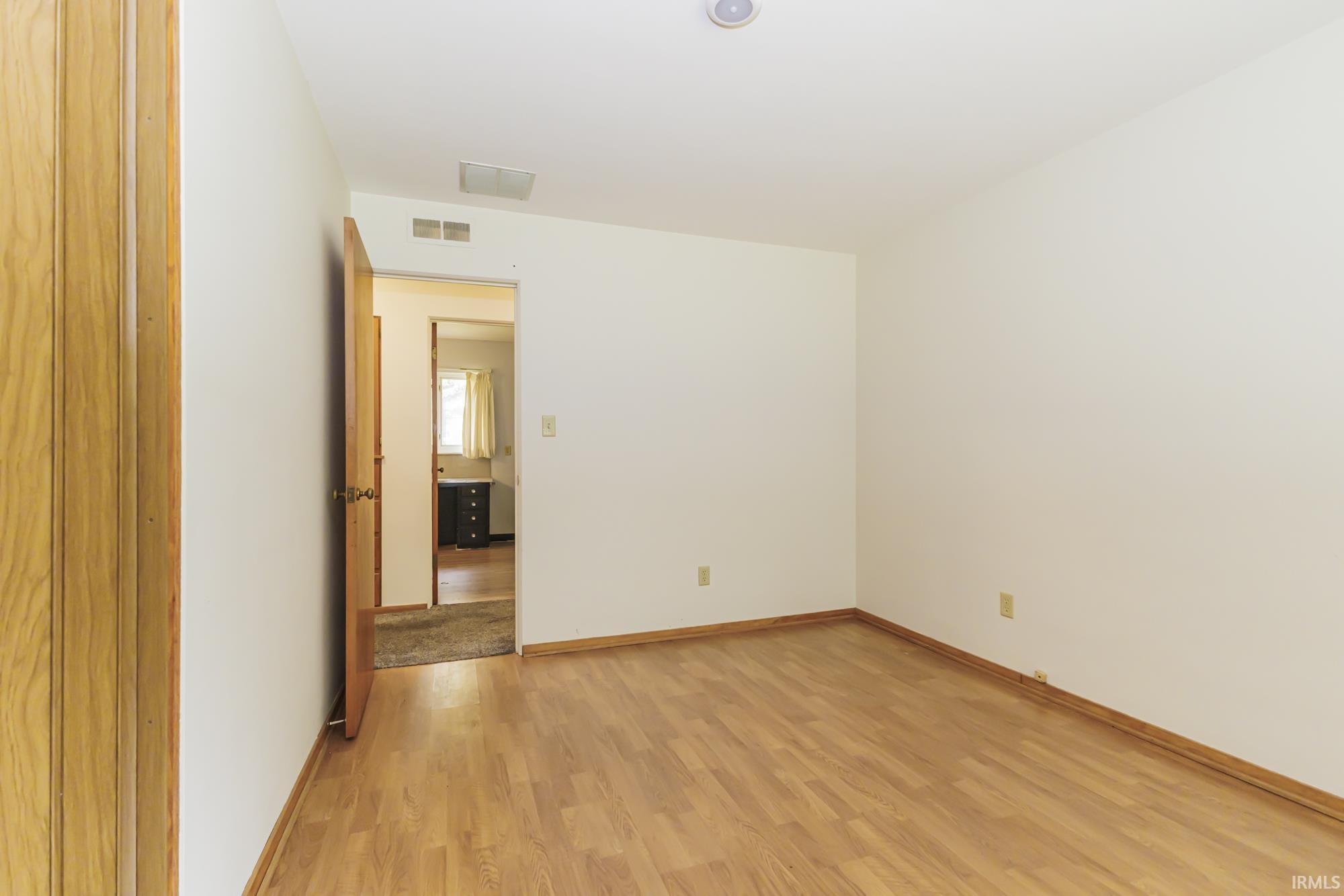 Room featuring wood-finish flooring, white walls, and a recessed ceiling light