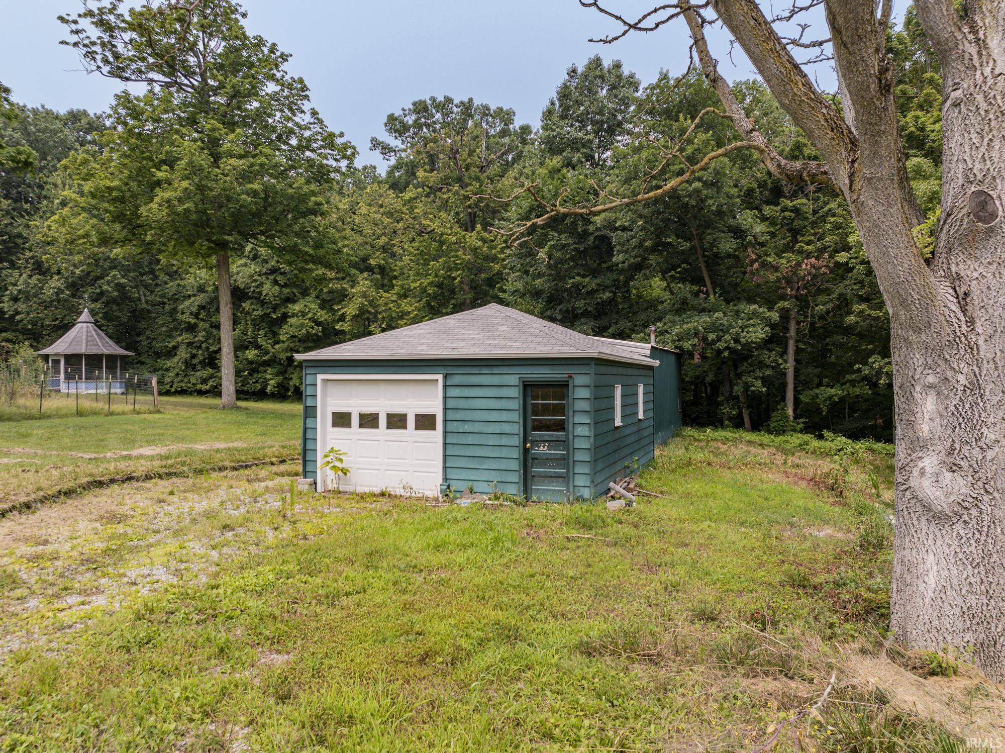 Detached garage with a paneled overhead door and a side entry door
