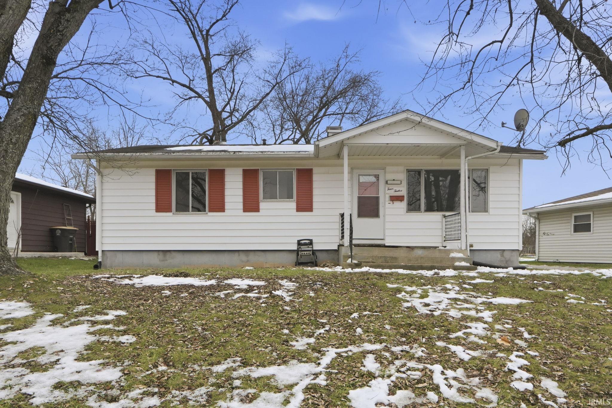 View of front of house featuring a chimney and covered porch