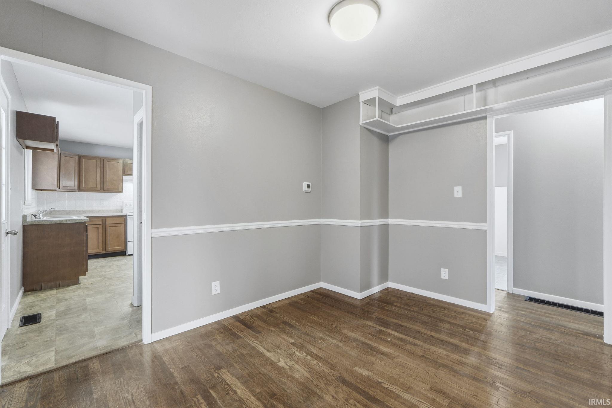 Empty room with dark wood finished floors and baseboards