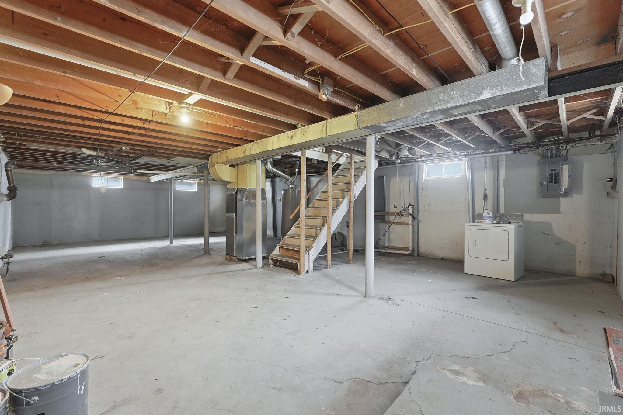 Basement featuring stairs, washer / clothes dryer, electric panel, heating unit, and water heater