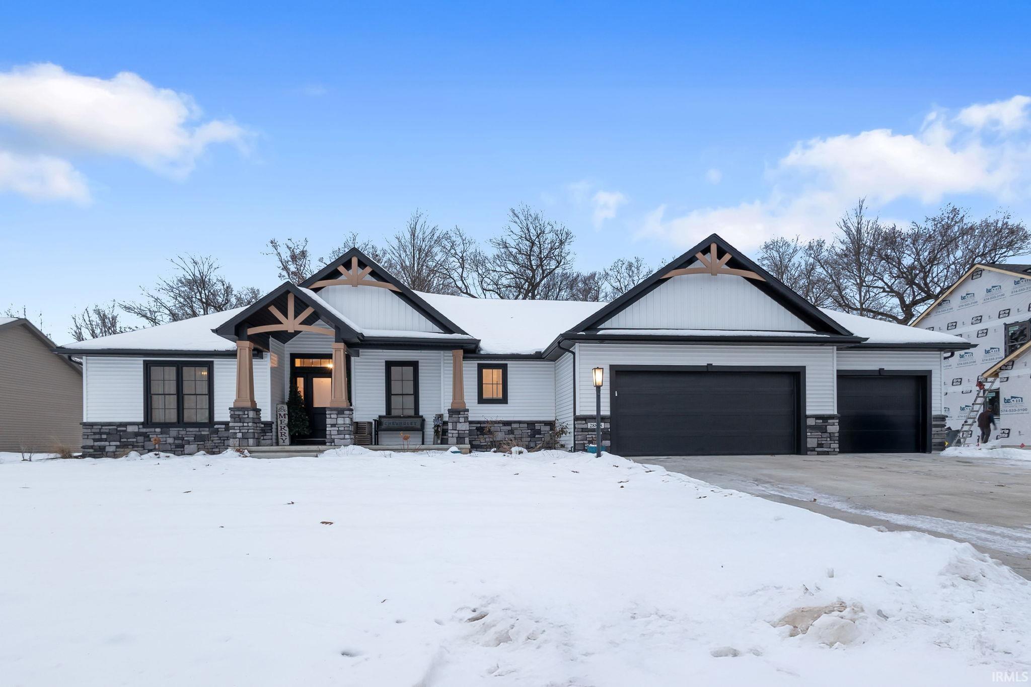 View of front of home with stone siding and a garage