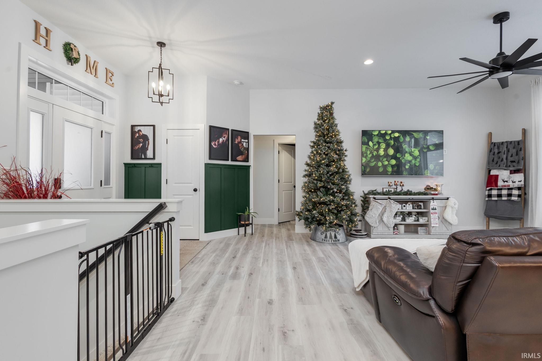 Living area featuring light wood-style floors, a chandelier, recessed lighting, and ceiling fan