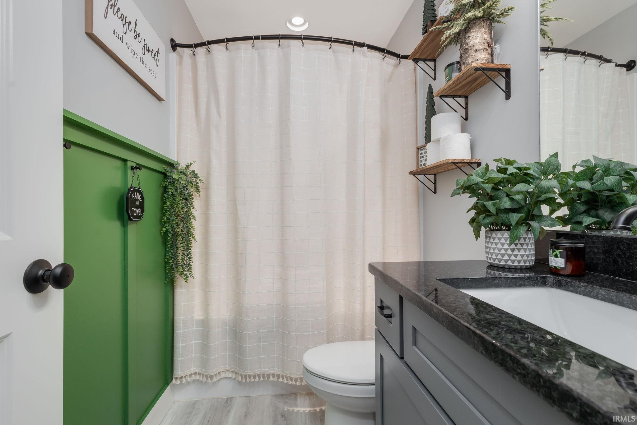 Bathroom with vanity, curtained shower, and light wood-style flooring