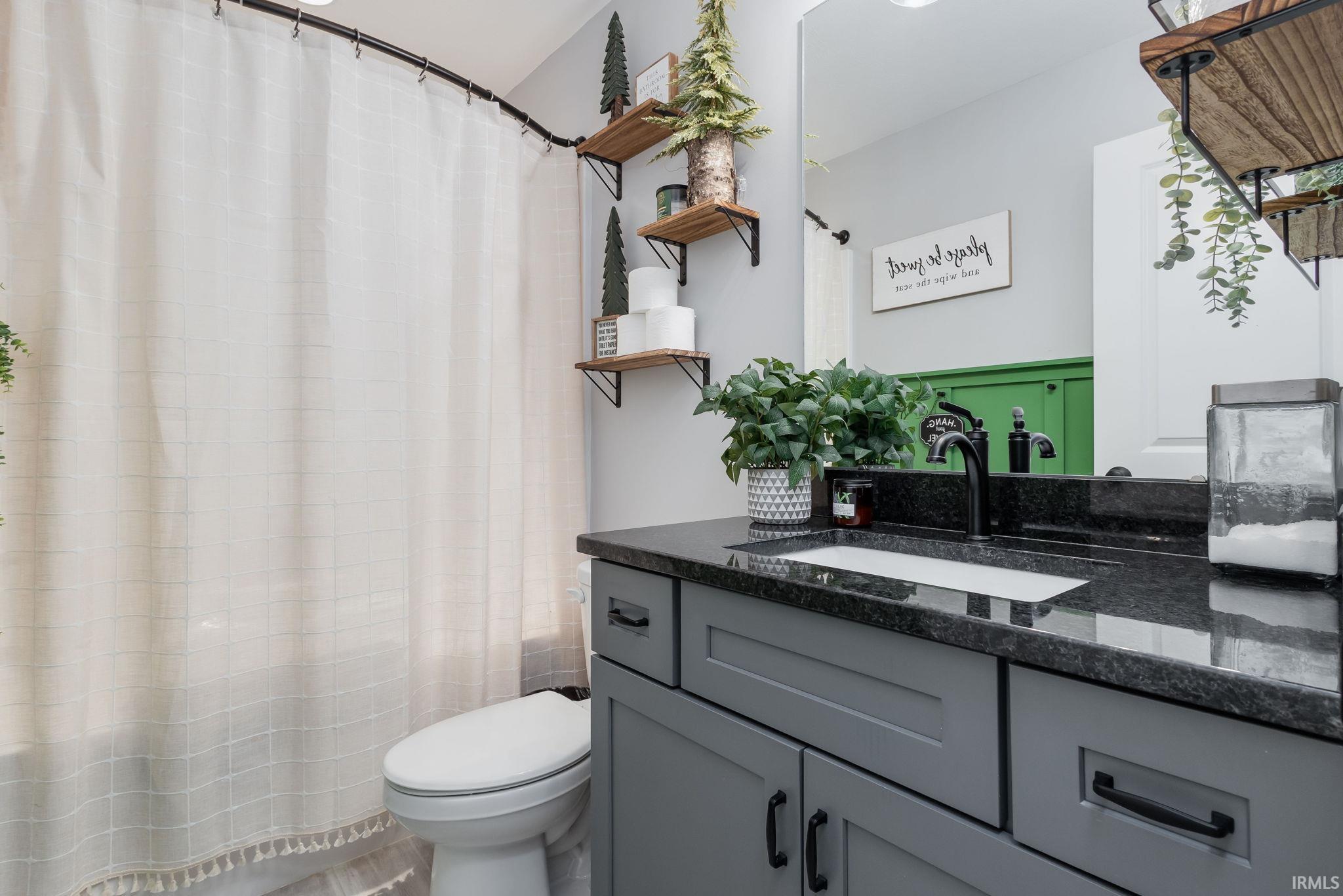 Full bath with vanity and a shower with shower curtain
