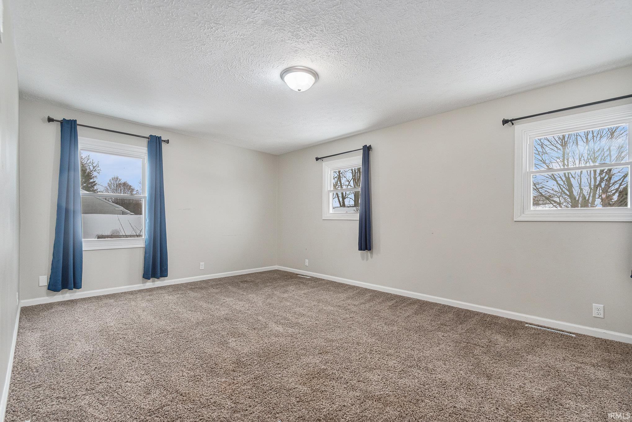 Spare room featuring carpet and a textured ceiling