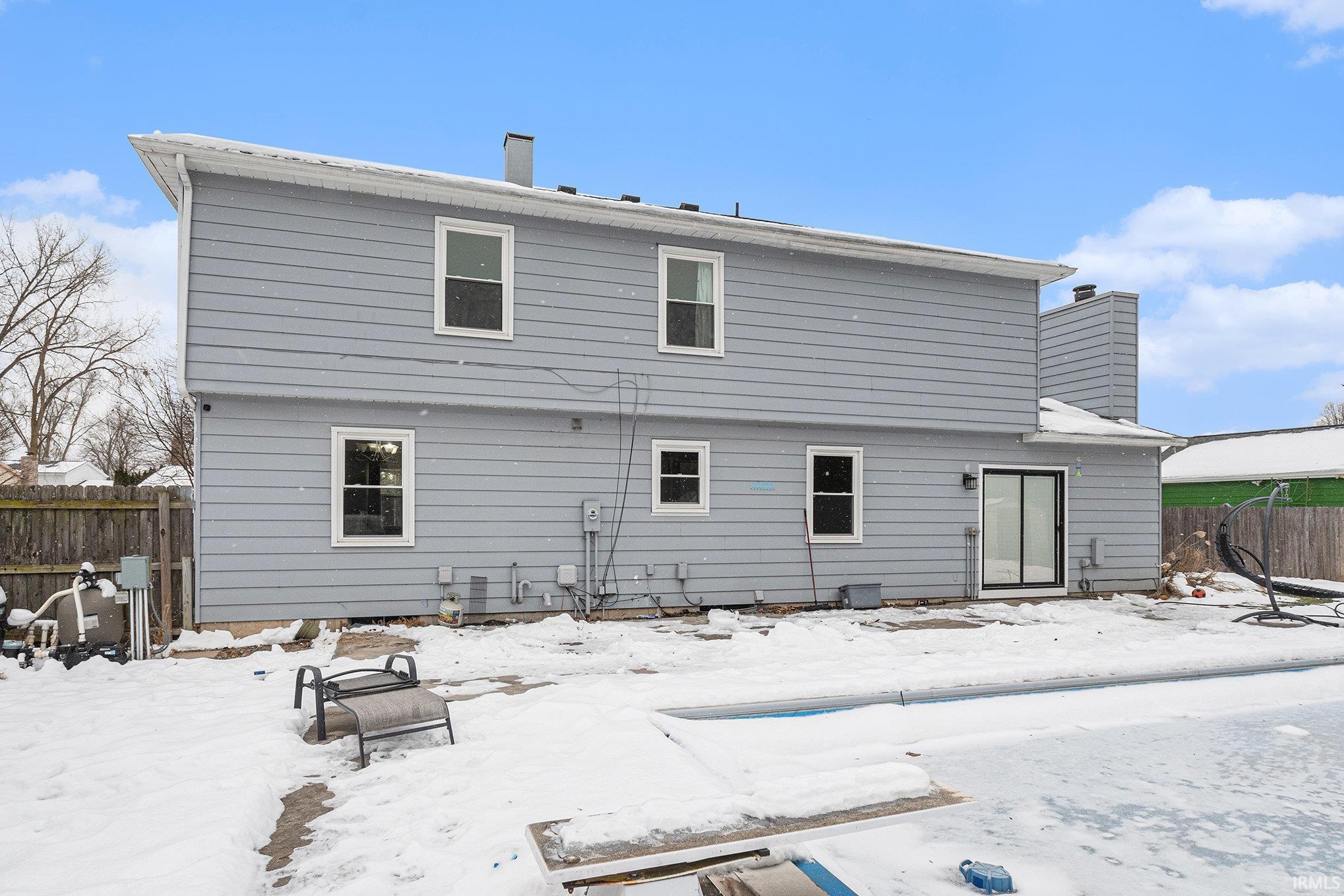 Snow covered house featuring a chimney