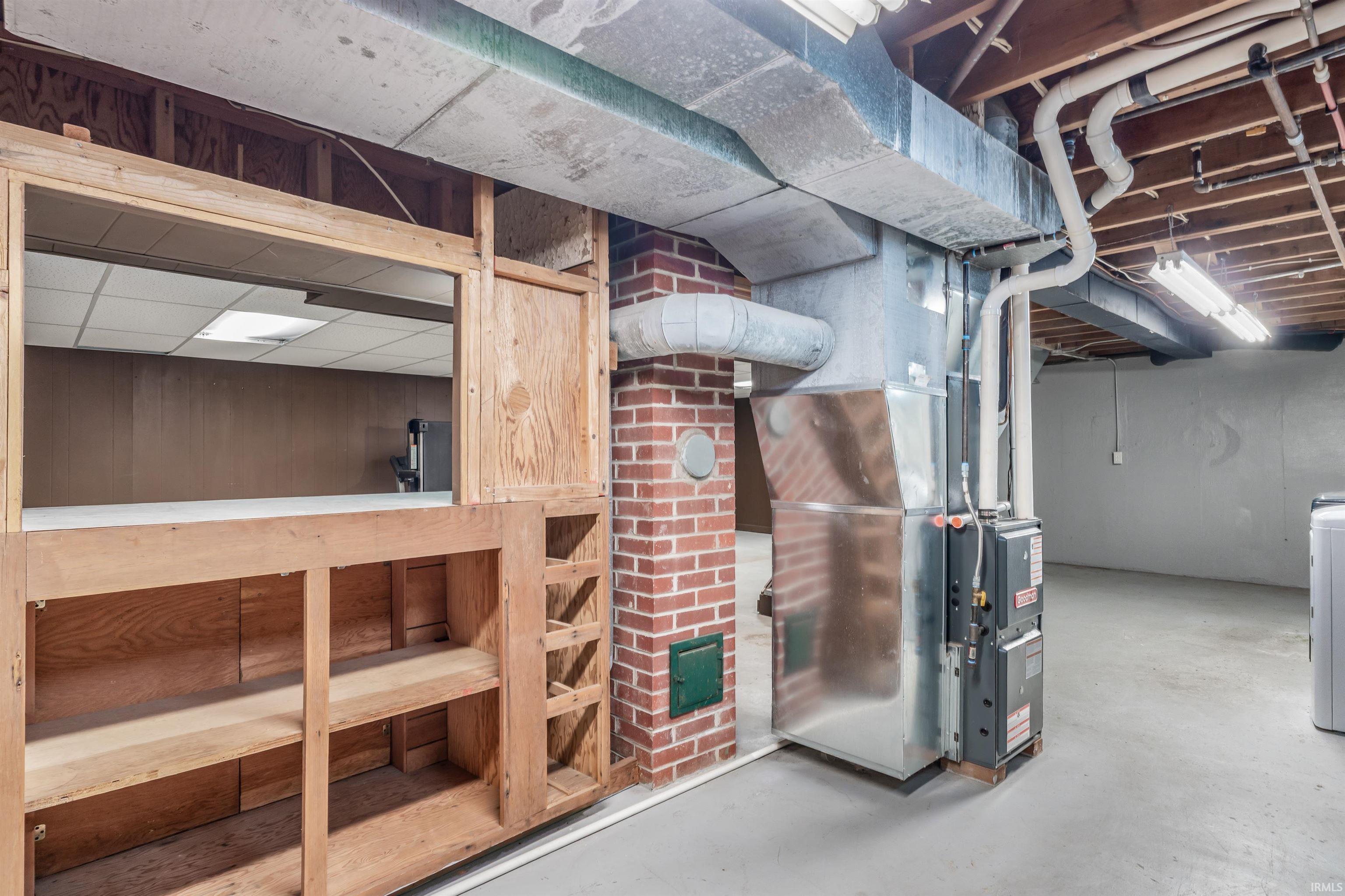 Unfinished below grade area with heating unit and washer / dryer