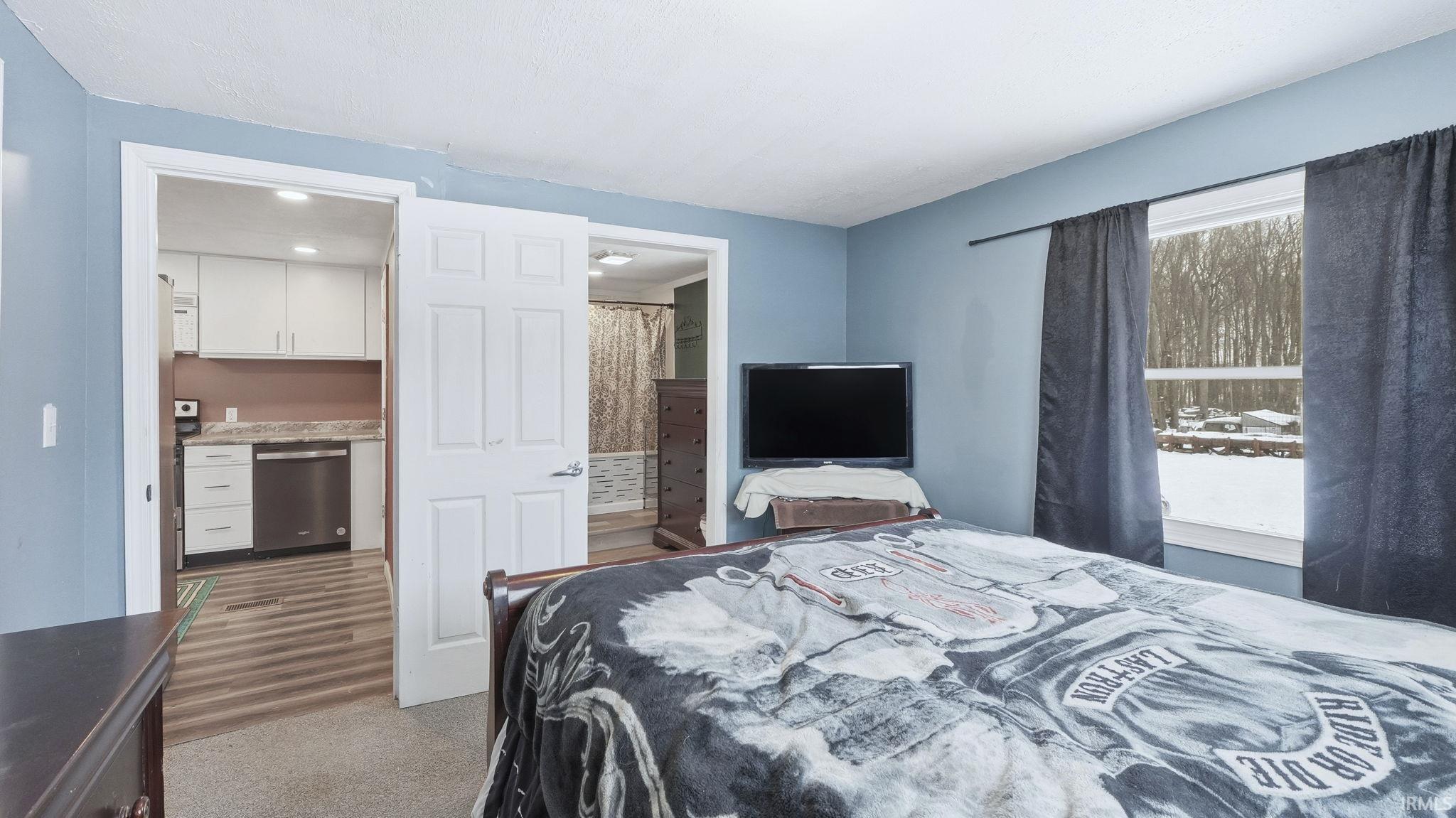 Bedroom with connected bathroom and carpet floors