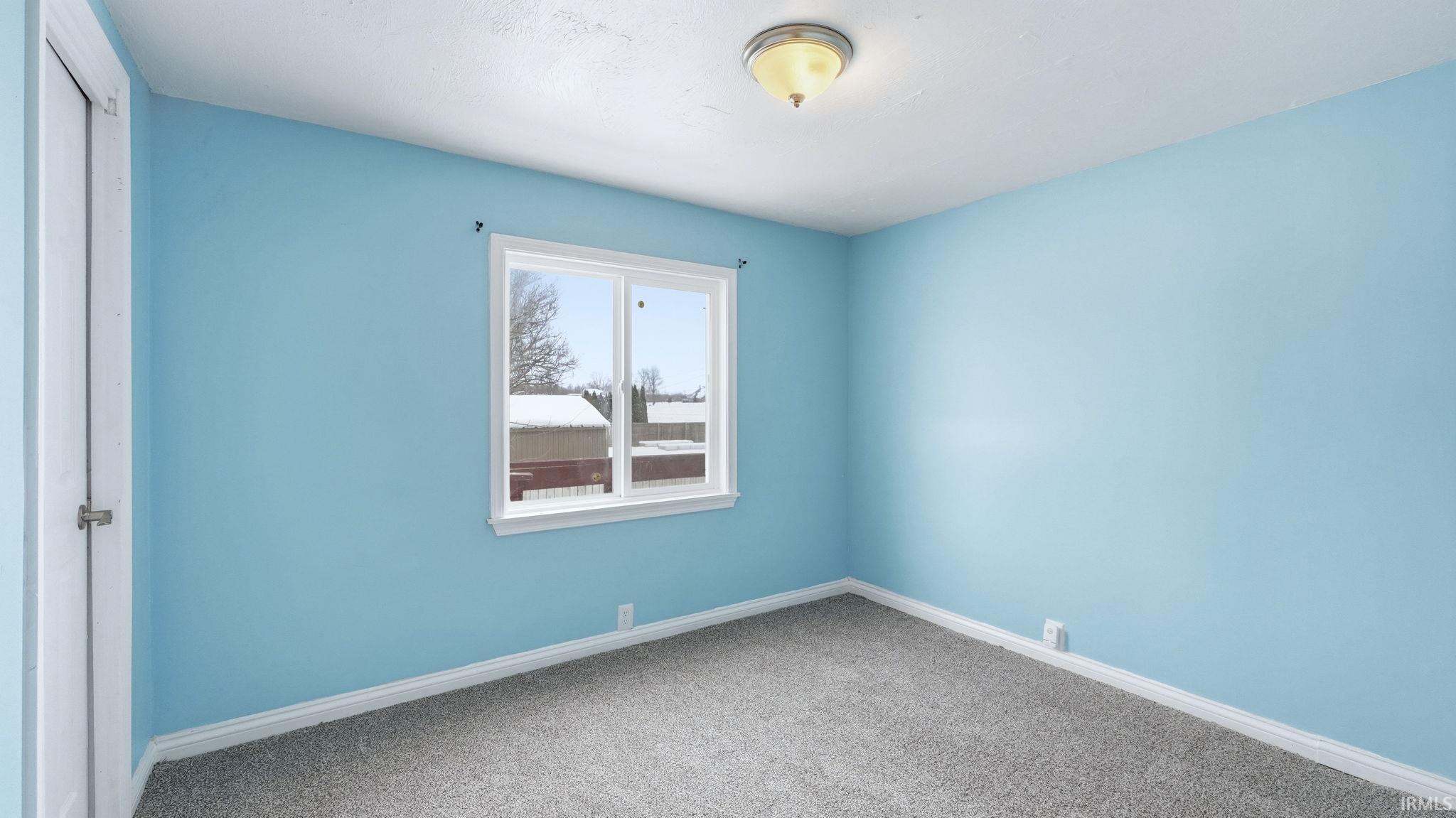Carpeted empty room with baseboards