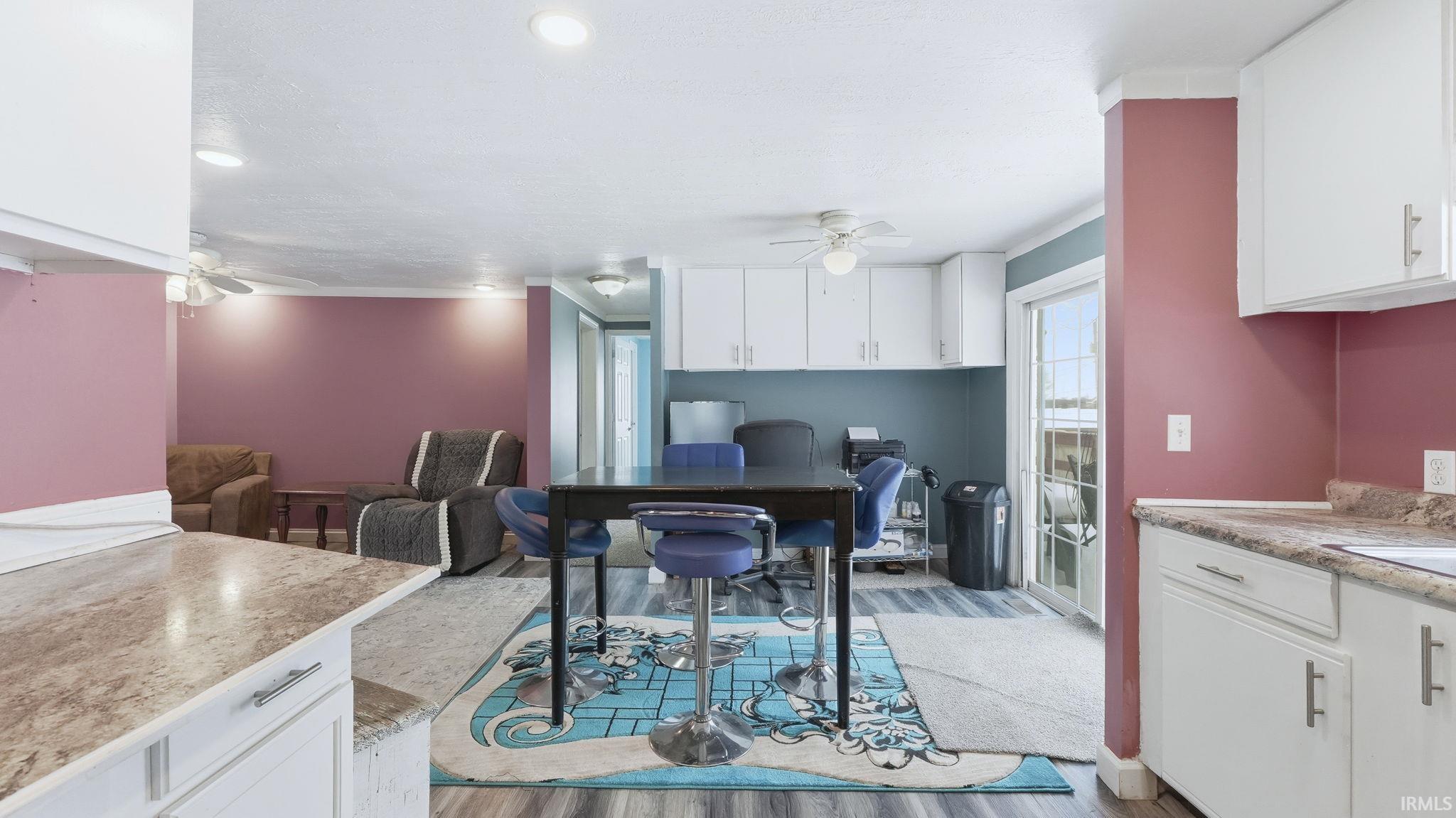 Kitchen with a ceiling fan, white cabinets, open floor plan, and recessed lighting