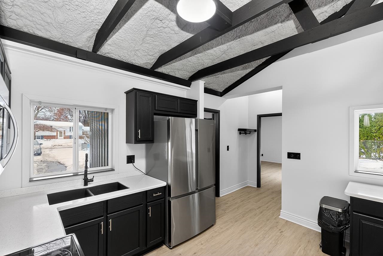 Kitchen featuring healthy amount of natural light and dark cabinetry