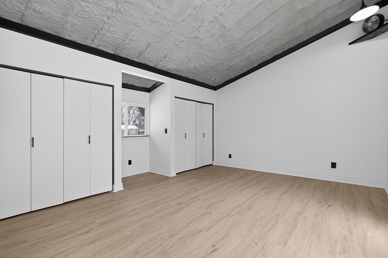 Unfurnished bedroom with multiple closets and light wood-style flooring
