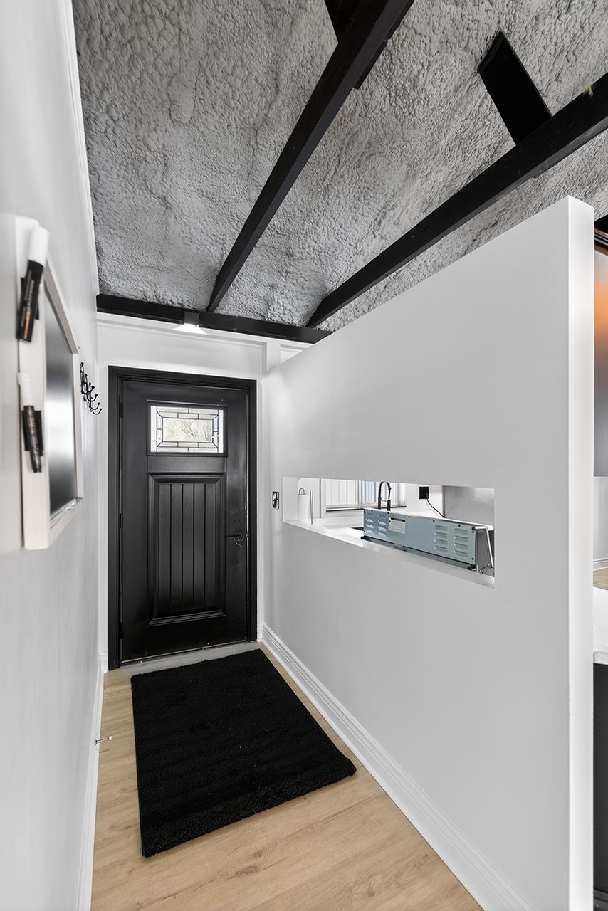 Entrance foyer featuring wood finished floors and beamed ceiling