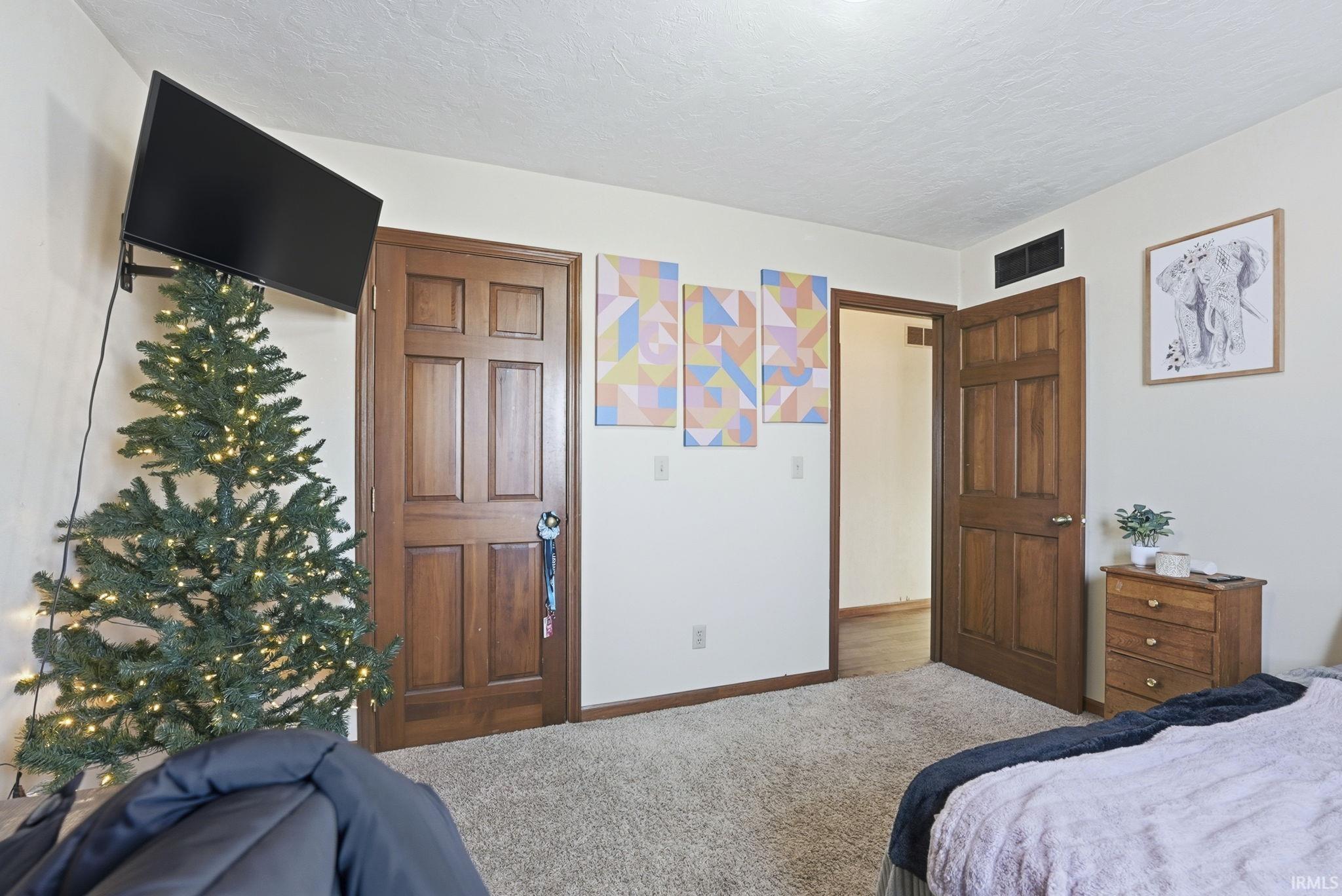 Bedroom with carpet floors and a textured ceiling