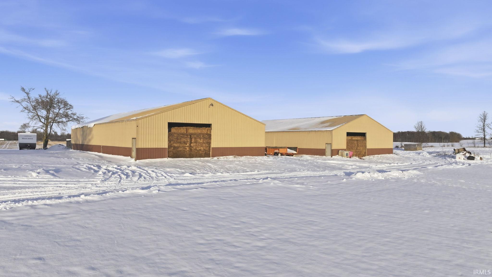 Snow covered structure with an outbuilding