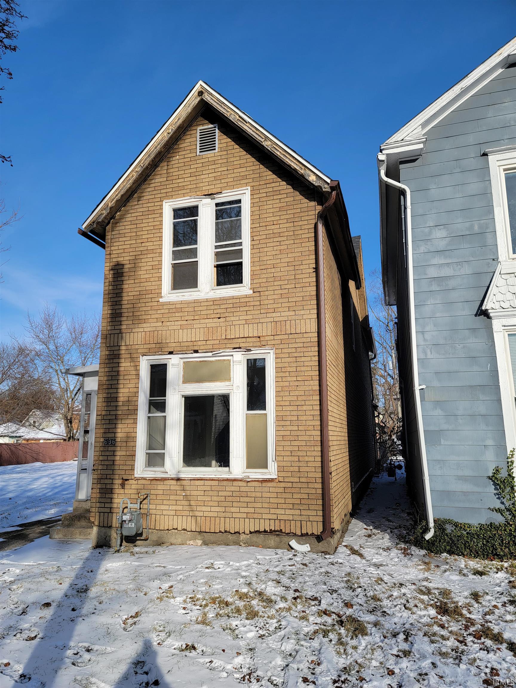Snow covered house with brick siding