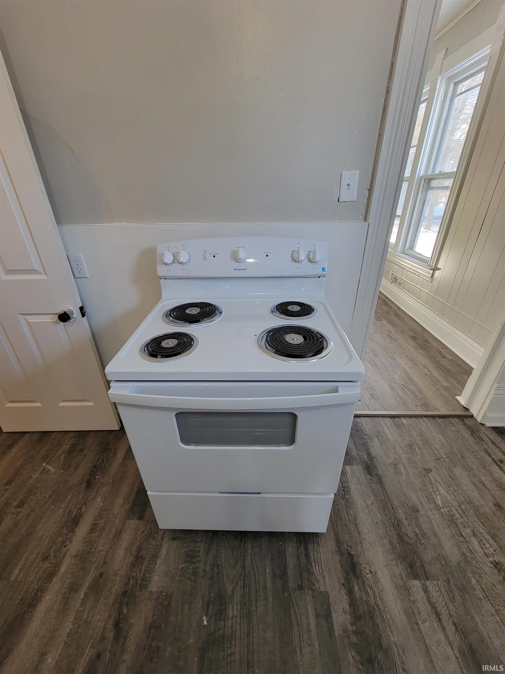 Kitchen view of white range with electric cooktop and dark wood finished floors