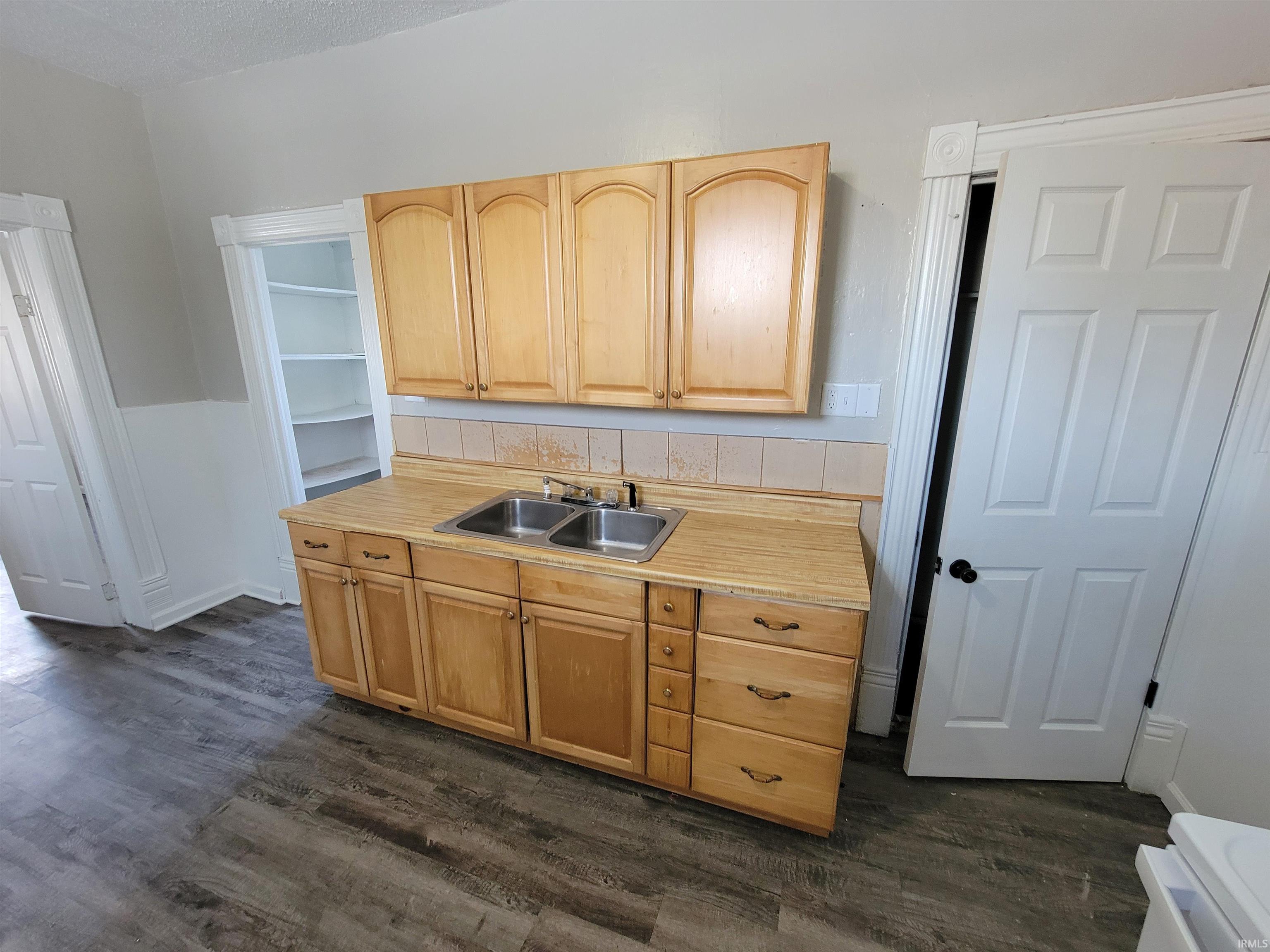 Kitchen featuring light countertops, dark wood-type flooring, white range oven, light brown cabinets, and a textured ceiling