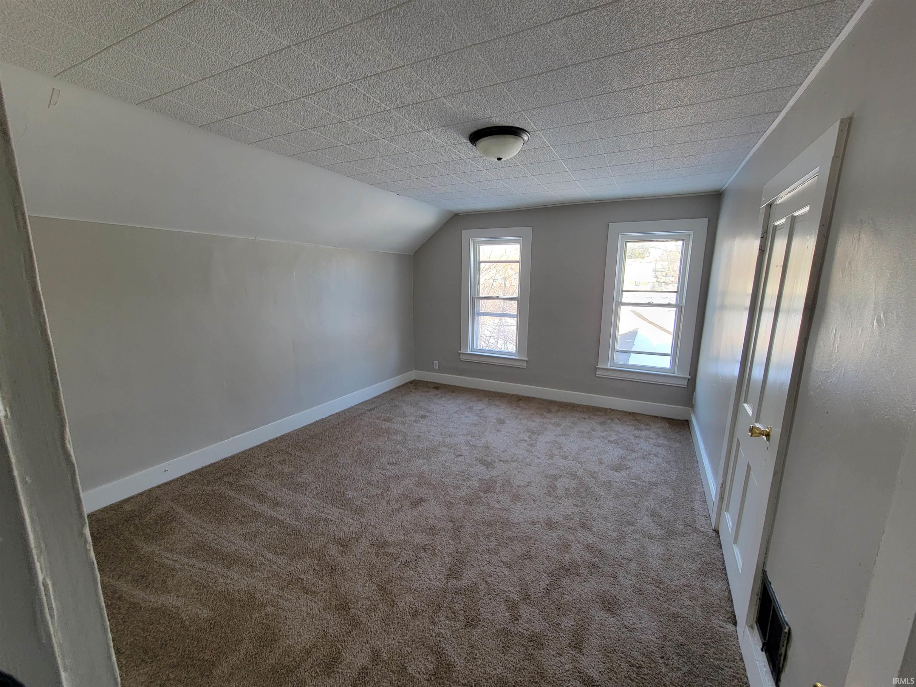 Bonus room featuring lofted ceiling and carpet floors