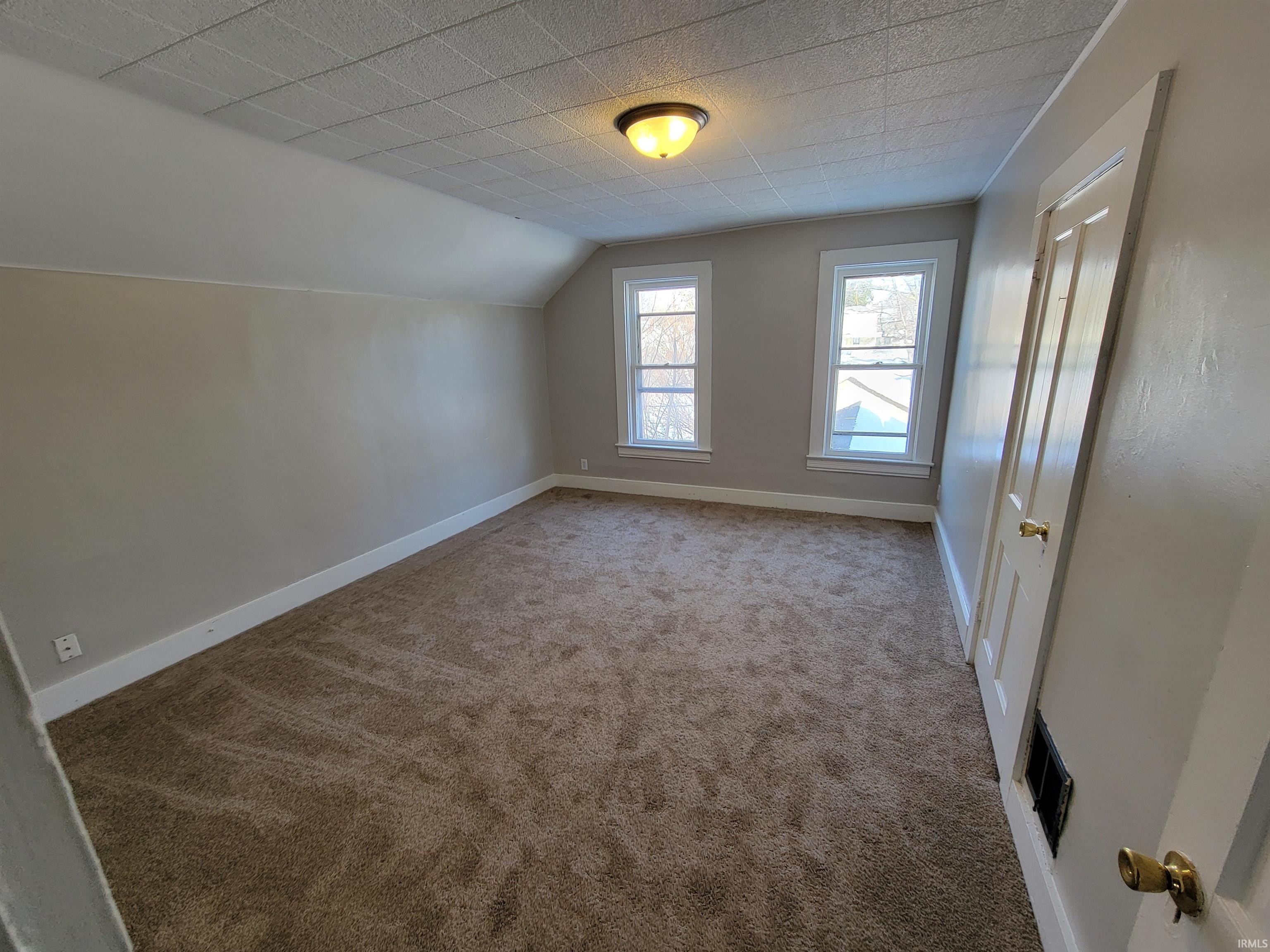 Bonus room with carpet floors and vaulted ceiling