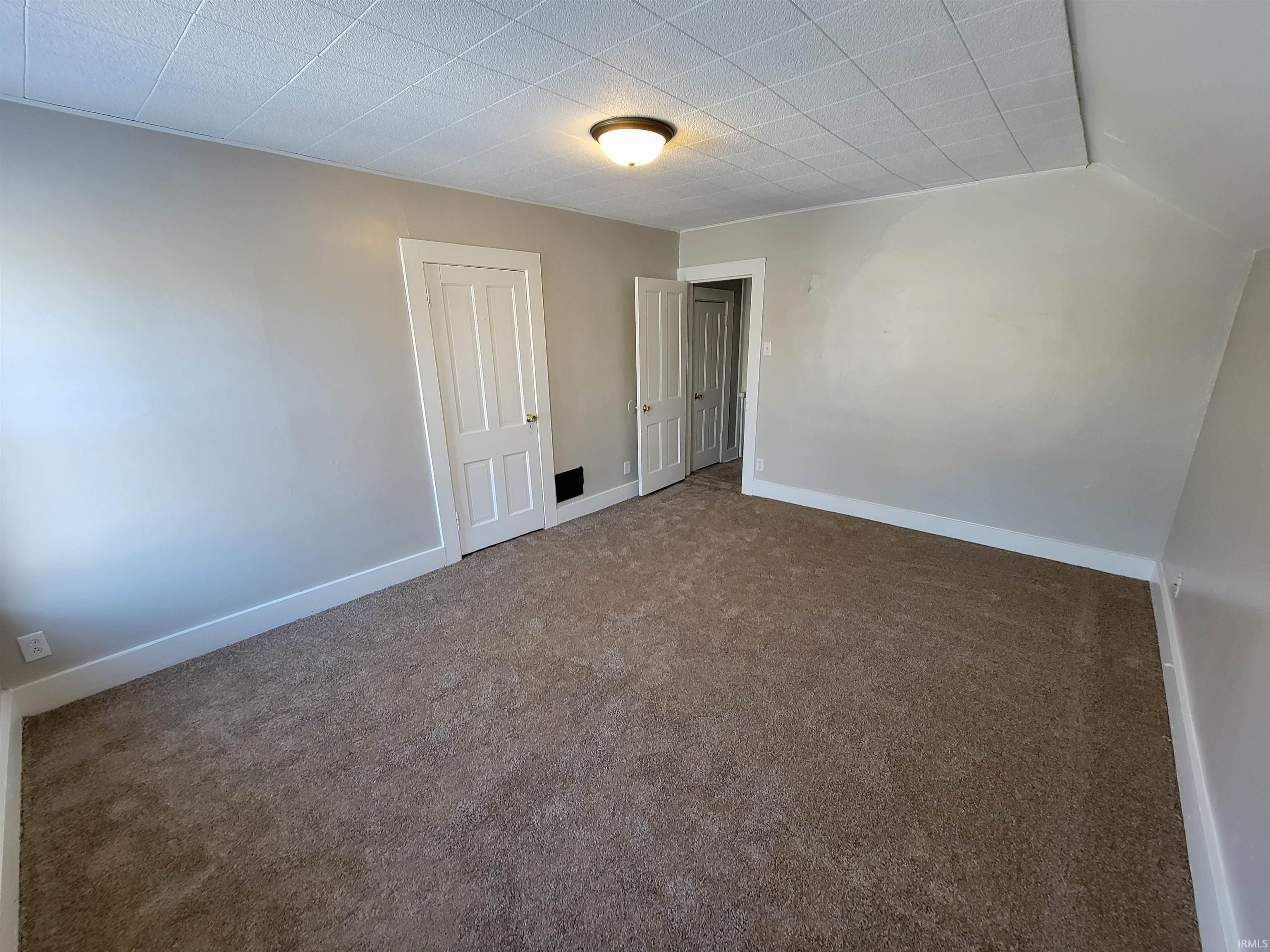 Spare room with carpet and baseboards