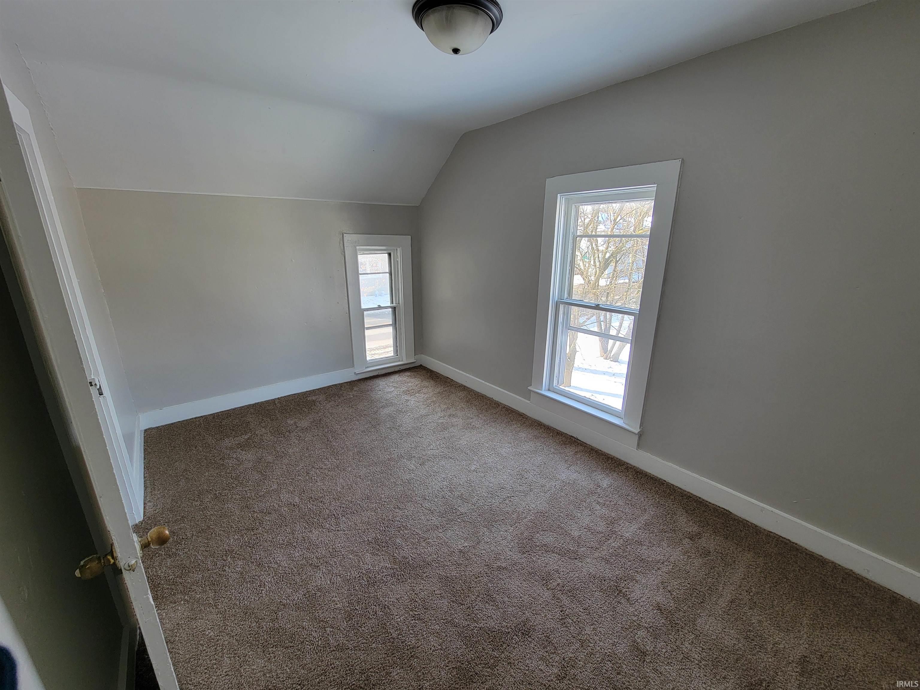 Bonus room featuring vaulted ceiling and carpet floors