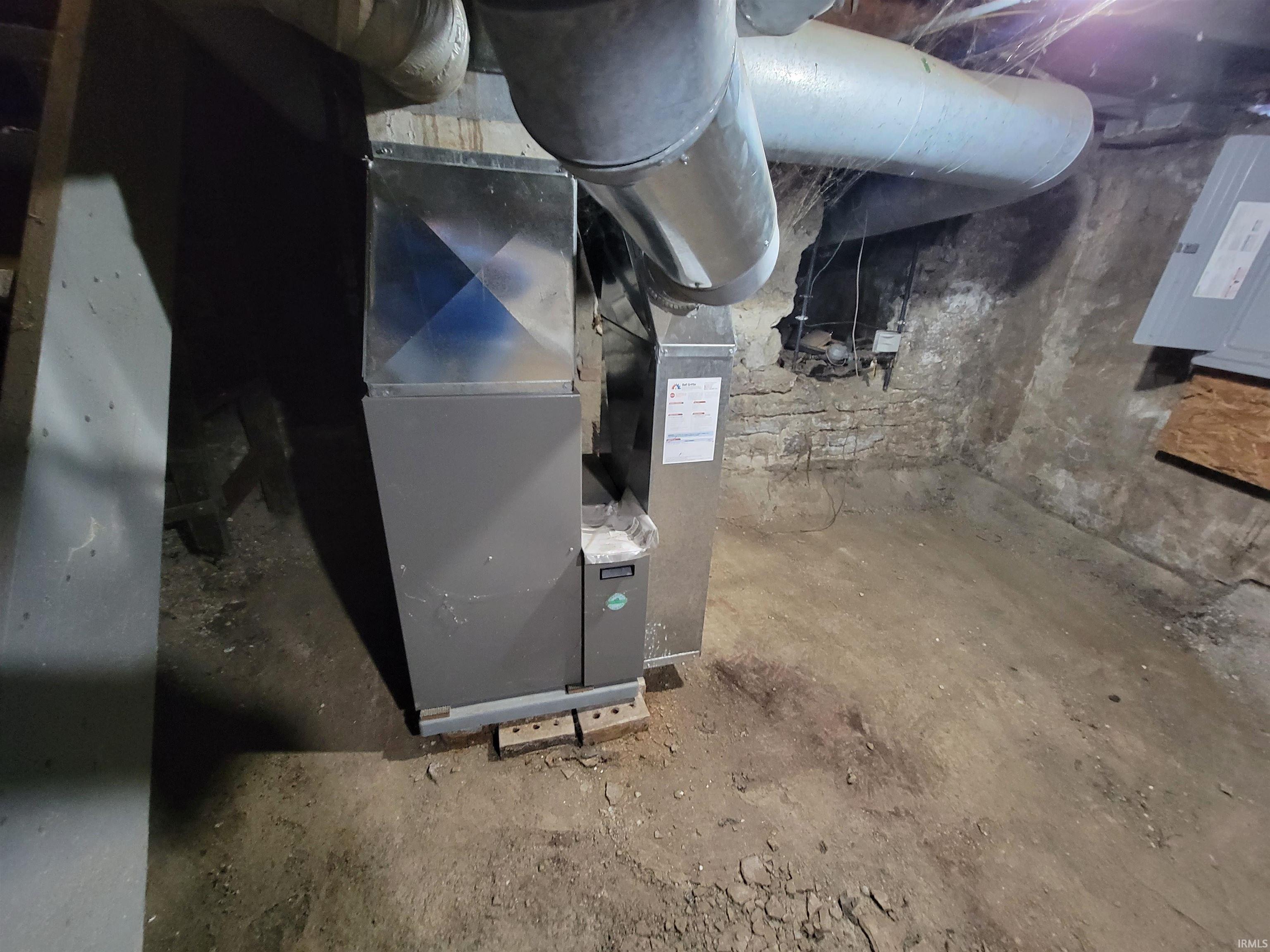 Utility room featuring heating unit and electric panel