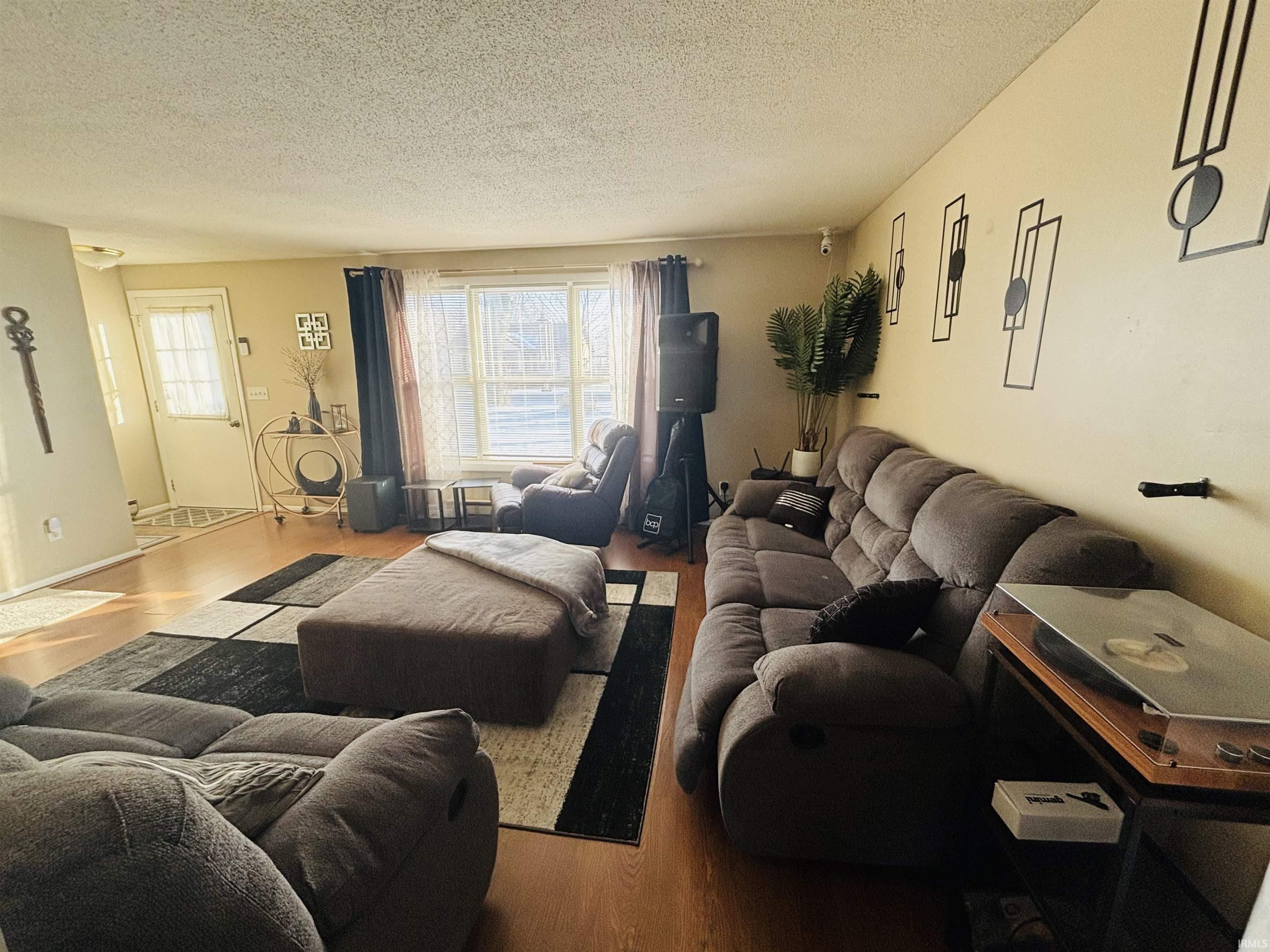Living room featuring wood finished floors and a textured ceiling