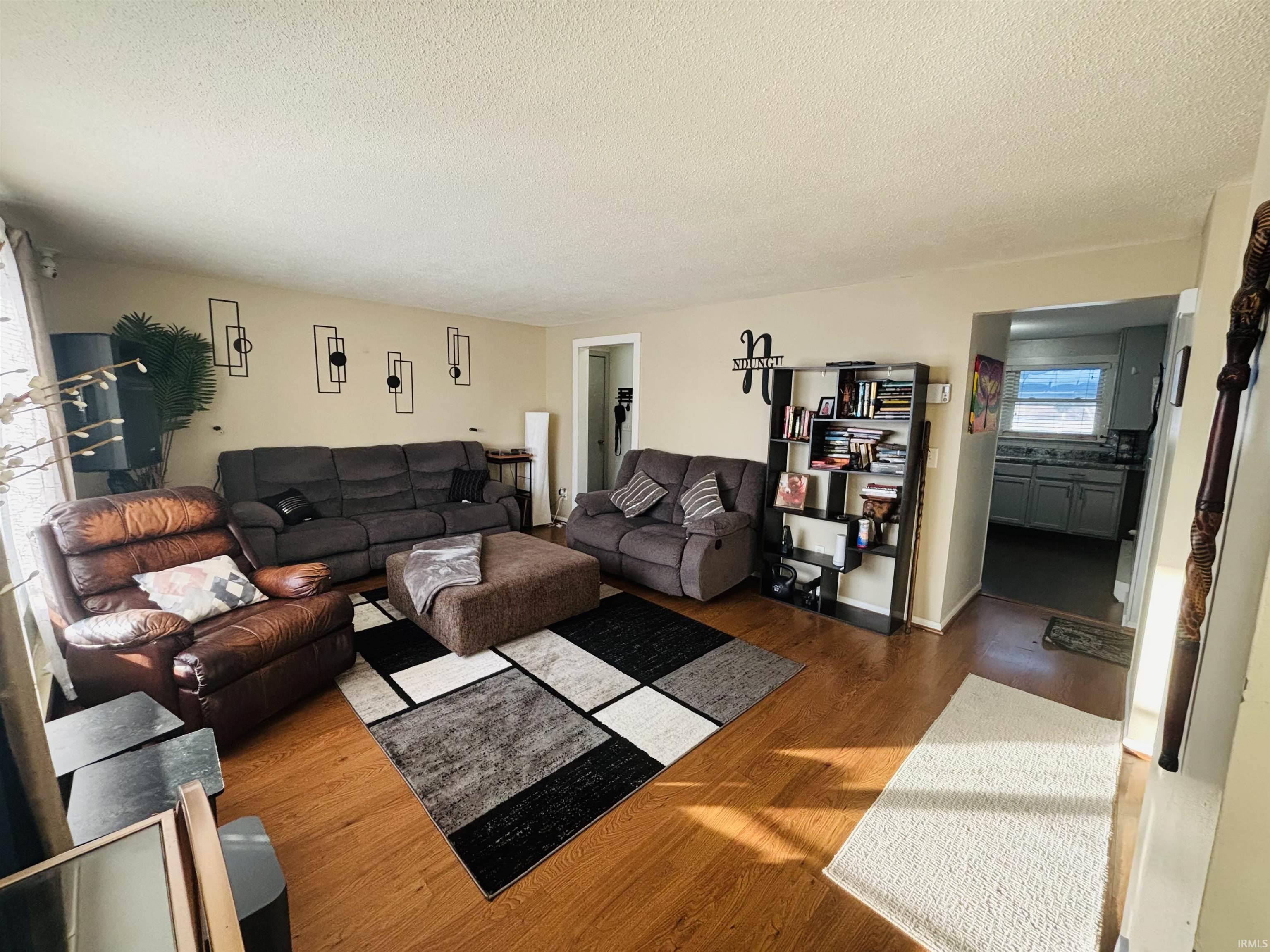 Living room featuring wood finished floors and a textured ceiling