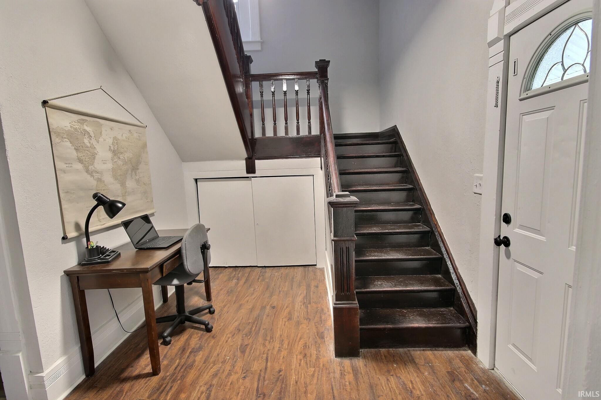 Stairs with wood finished floors and baseboards