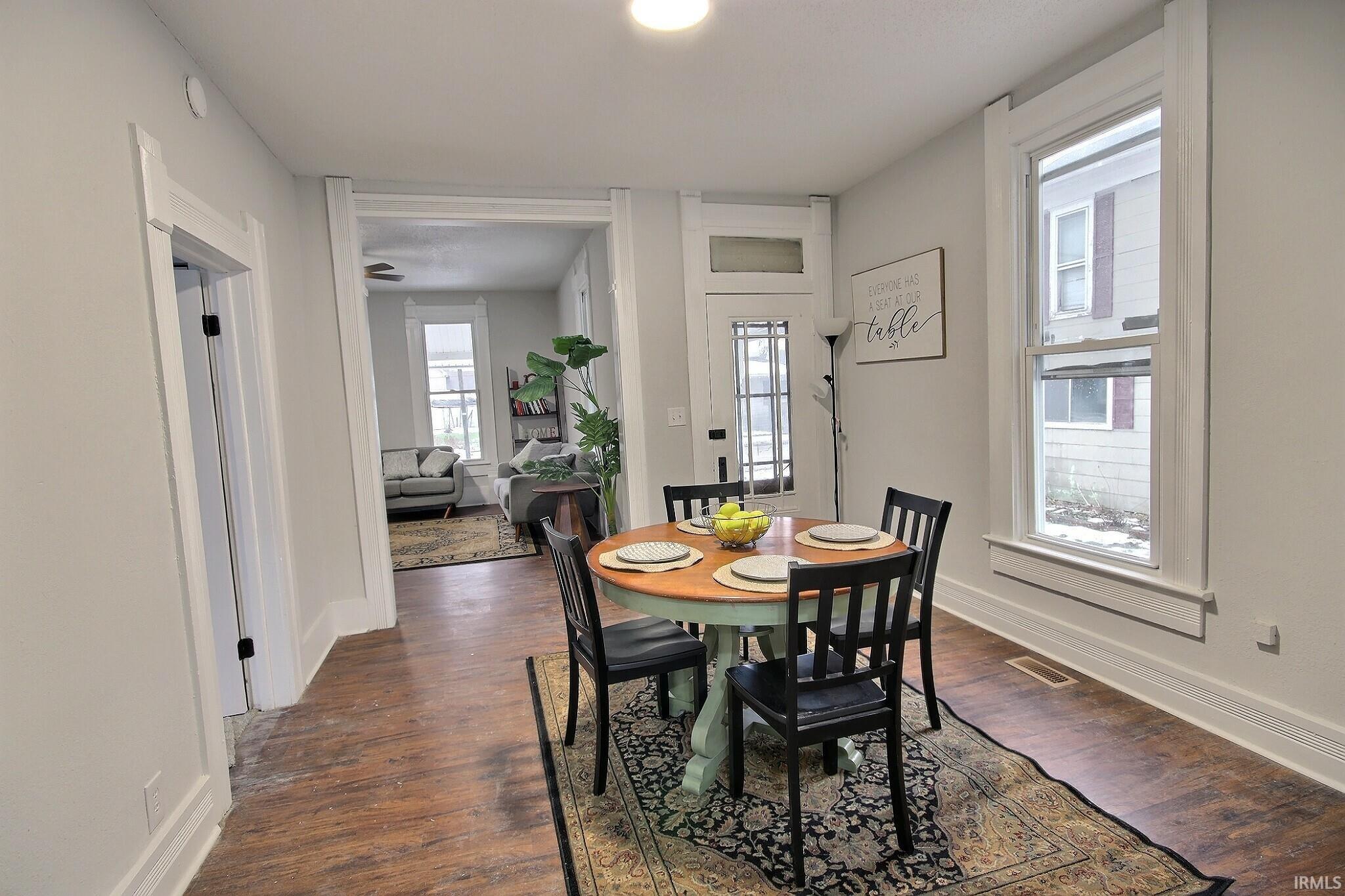 Dining room with dark wood finished floors and baseboards