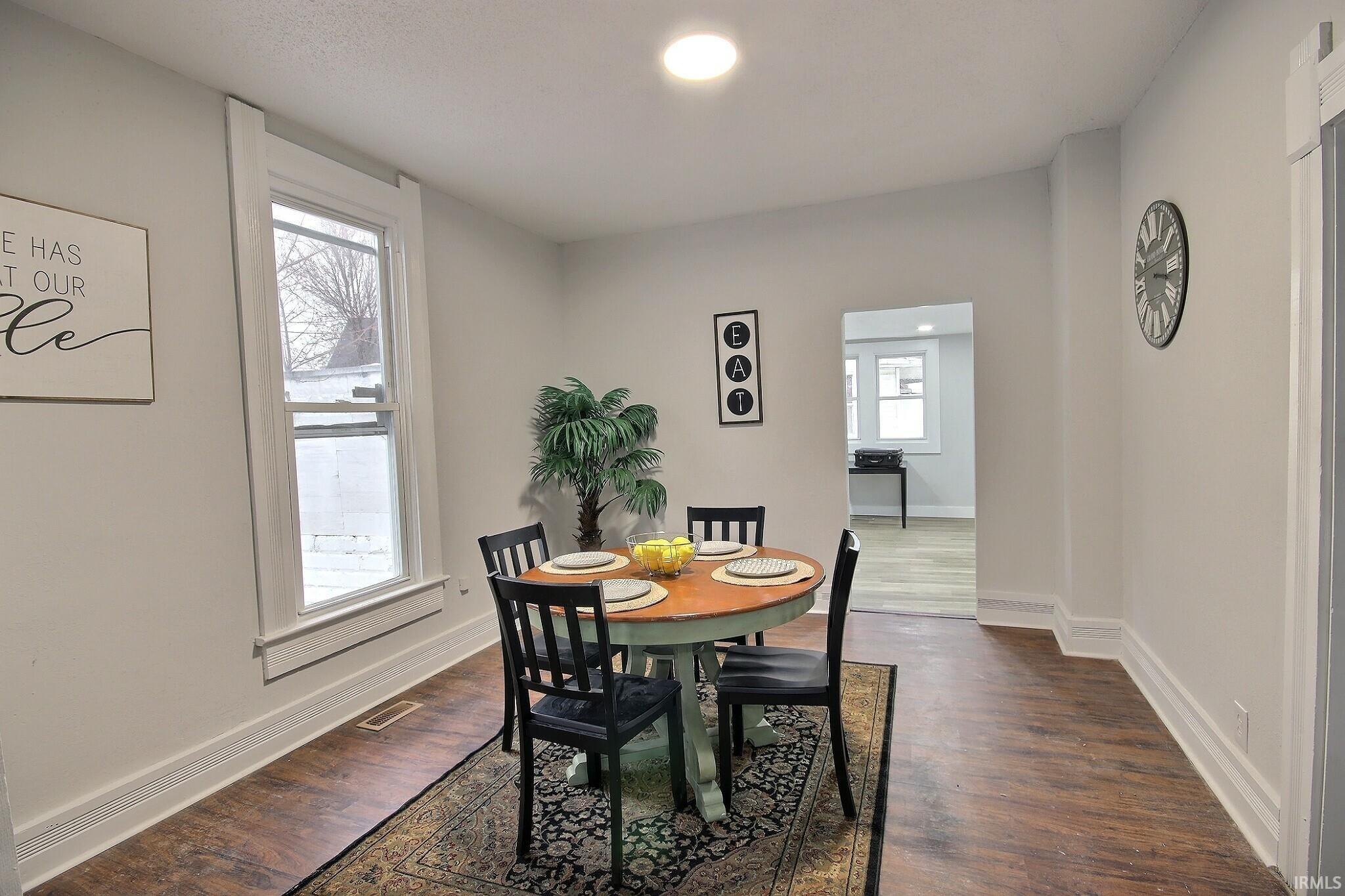 Dining space with dark wood-style floors and recessed lighting