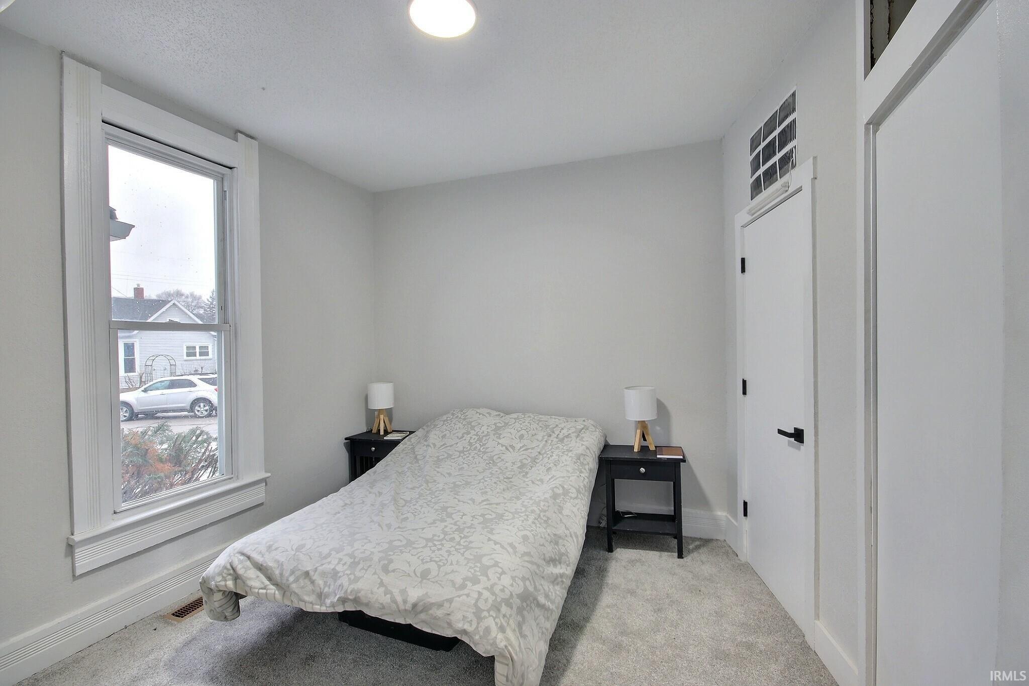 Bedroom with light carpet and baseboards