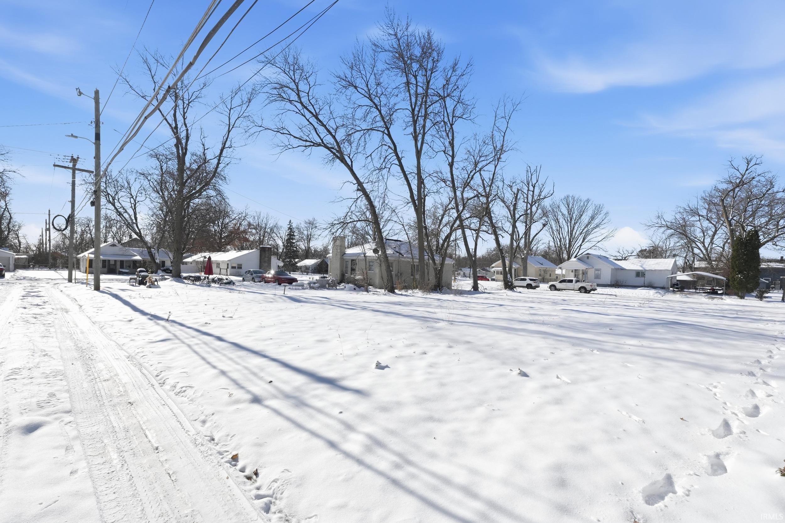 Yard layered in snow with a residential view