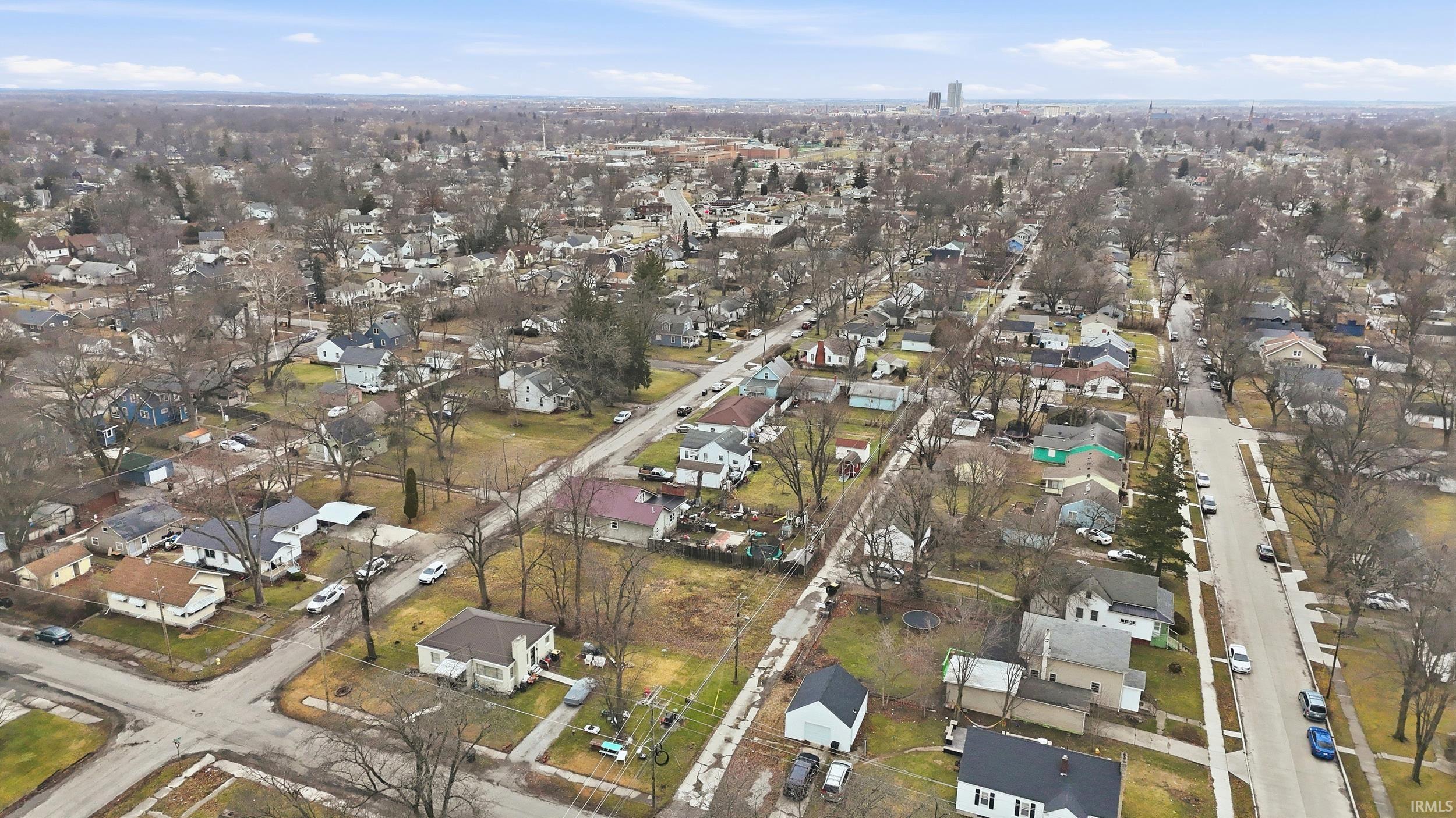 Aerial view of property and surrounding area with nearby suburban area