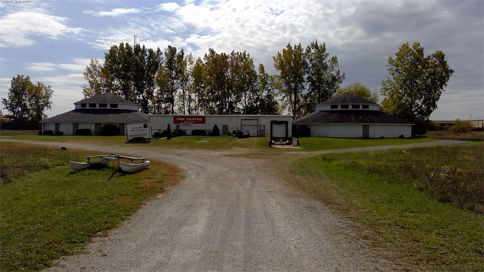 View of front of property featuring dirt driveway, a garage, and a front yard