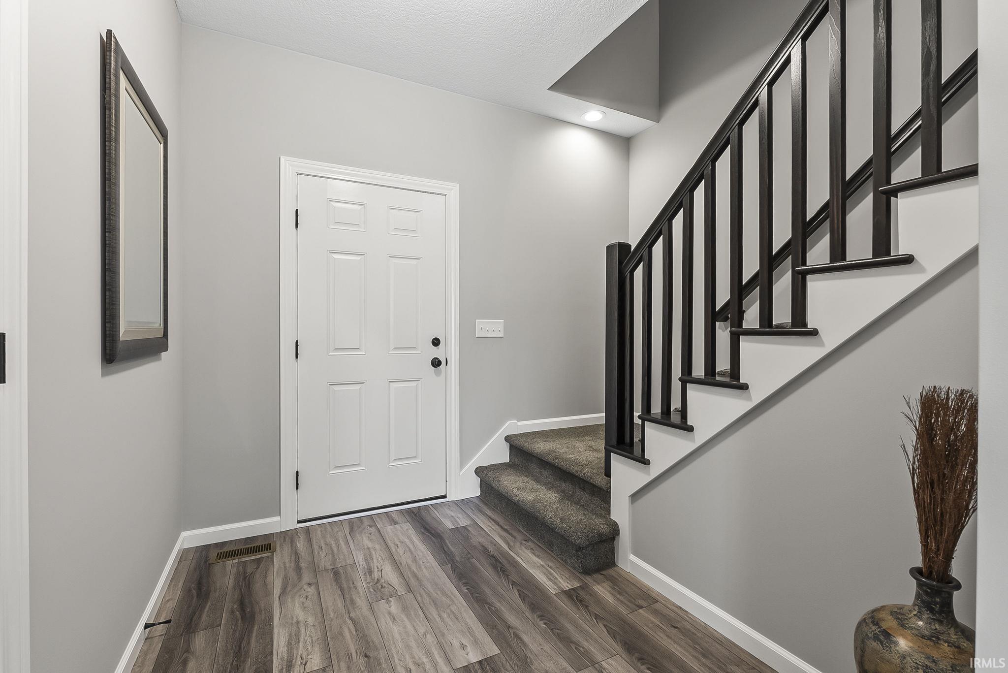 Foyer featuring dark wood-style flooring and recessed lighting