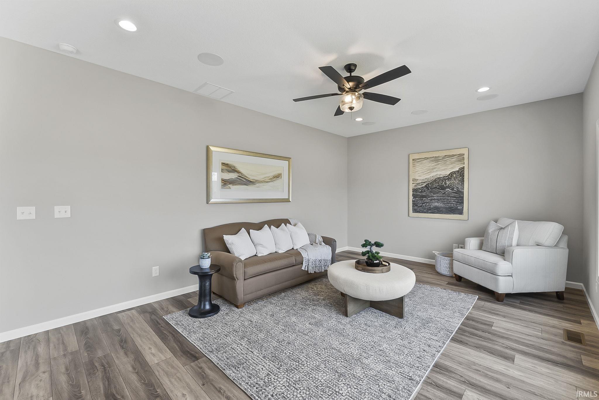 Living room with ceiling fan, recessed lighting, and light wood finished floors