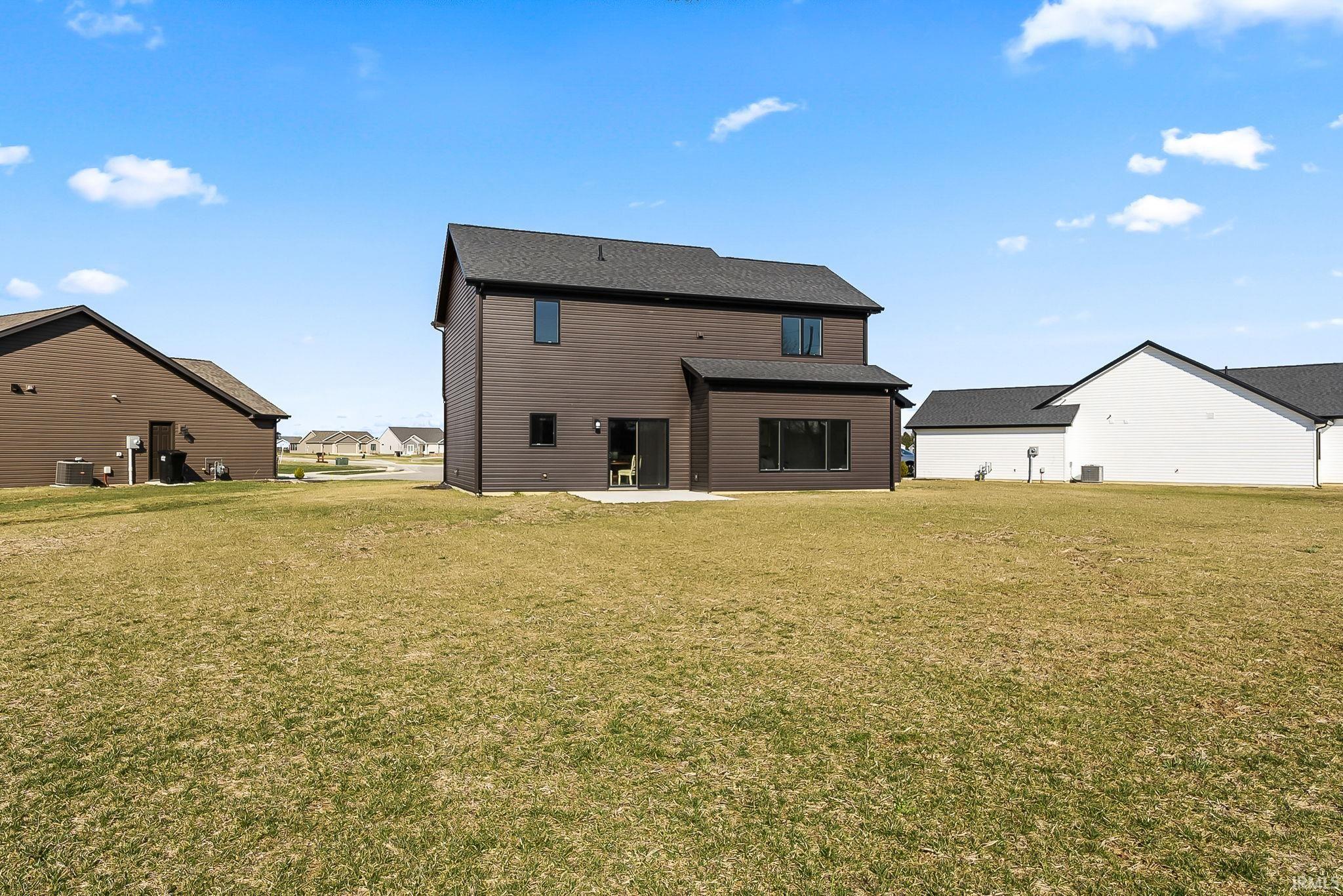 Rear view of property featuring a yard and a patio