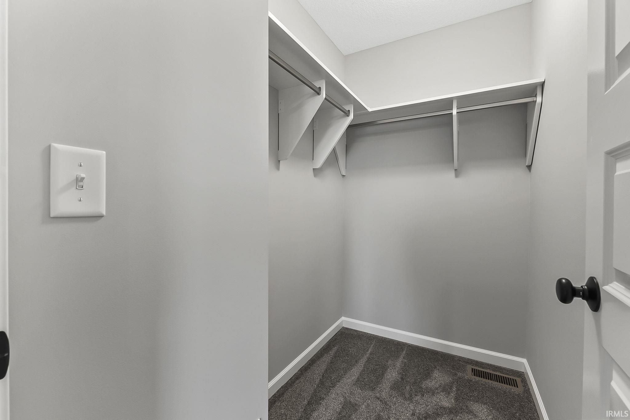 Walk in closet with dark carpet