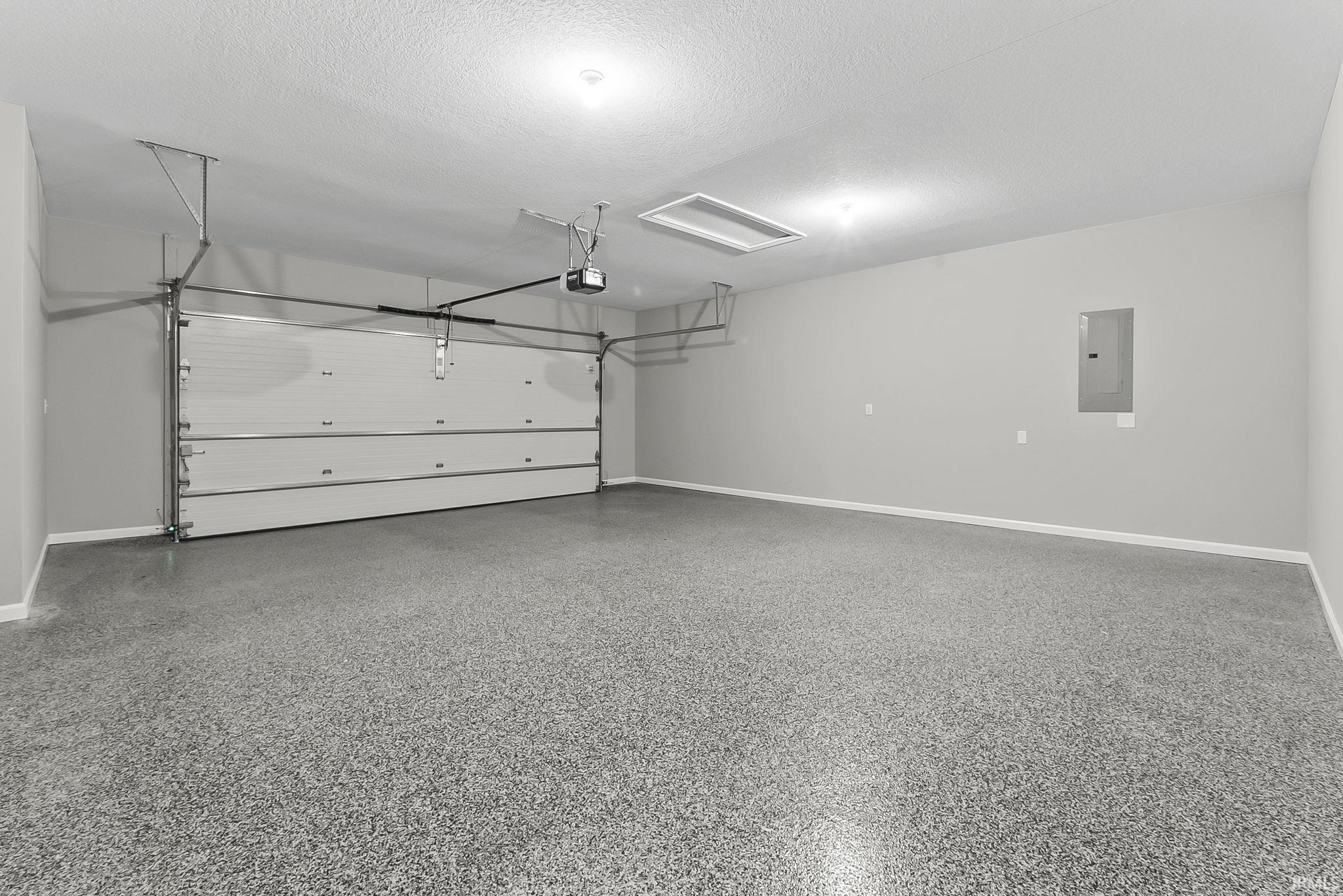 Garage with electric panel and baseboards